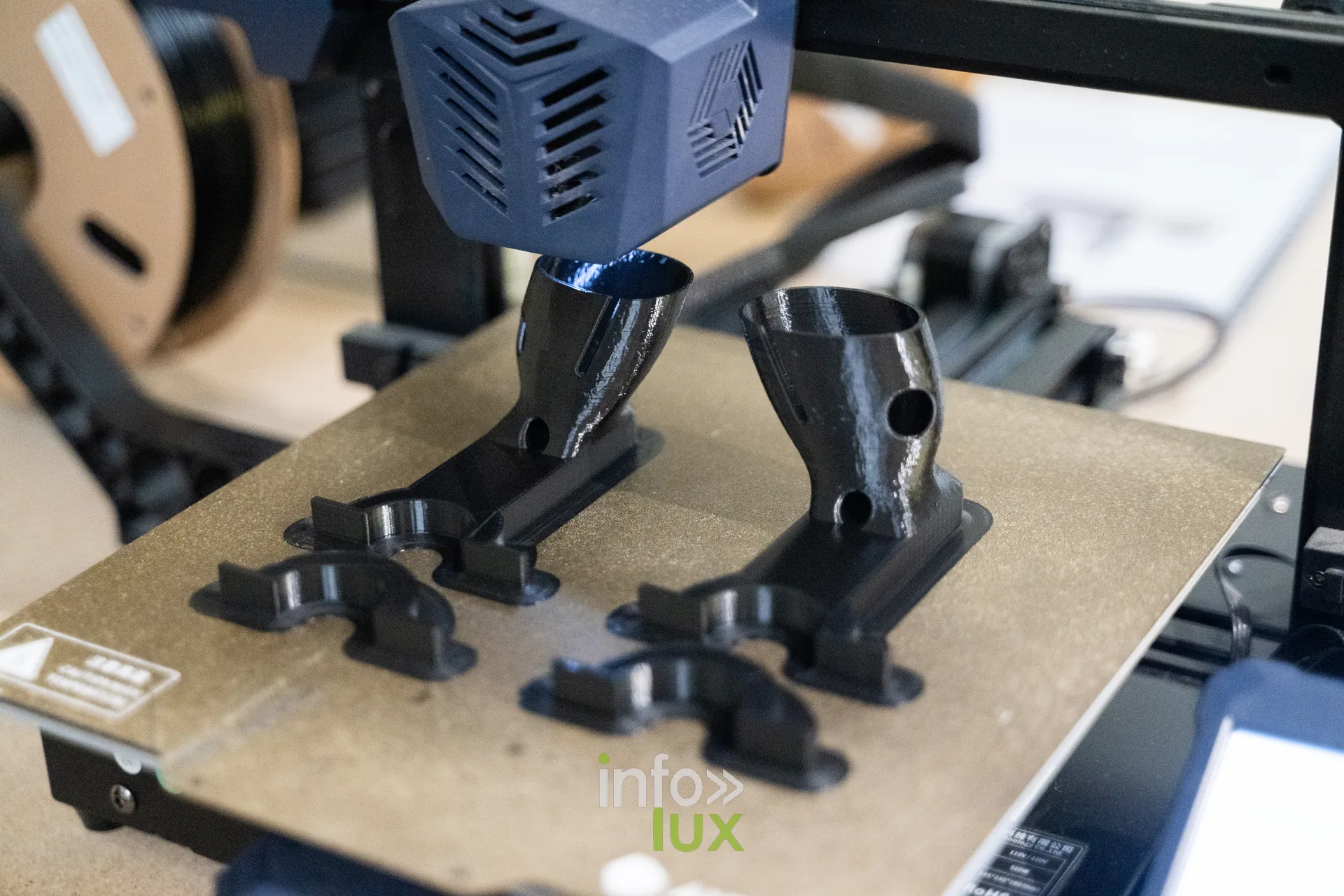 Imprimante 3D en fonctionnement produisant des pièces noires dans le fablab de la HEAJ à Namur