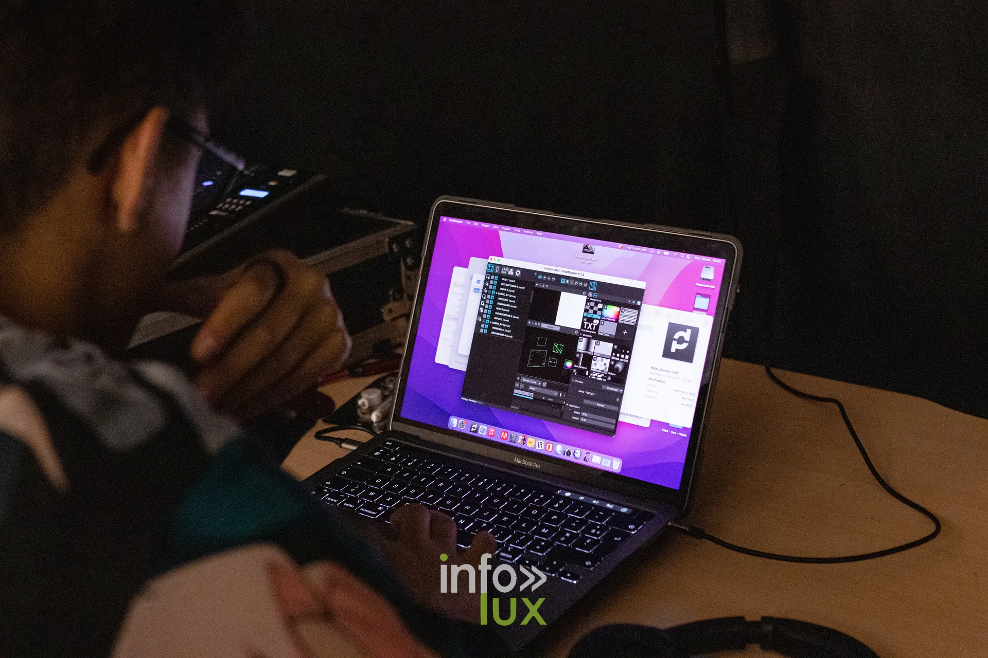 Étudiant travaillant sur un logiciel de création devant son ordinateur portable, écran magenta