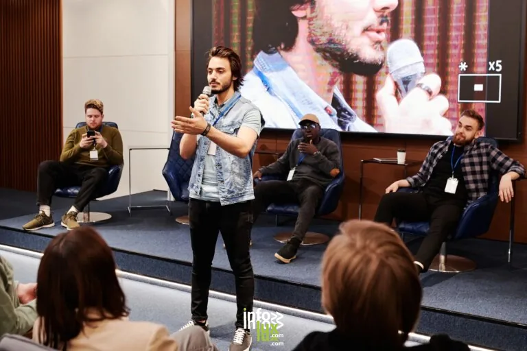 Le conférencier tient un microphone, captivant l'audience lors d'une conférence d'affaires intérieure avec un panel en a