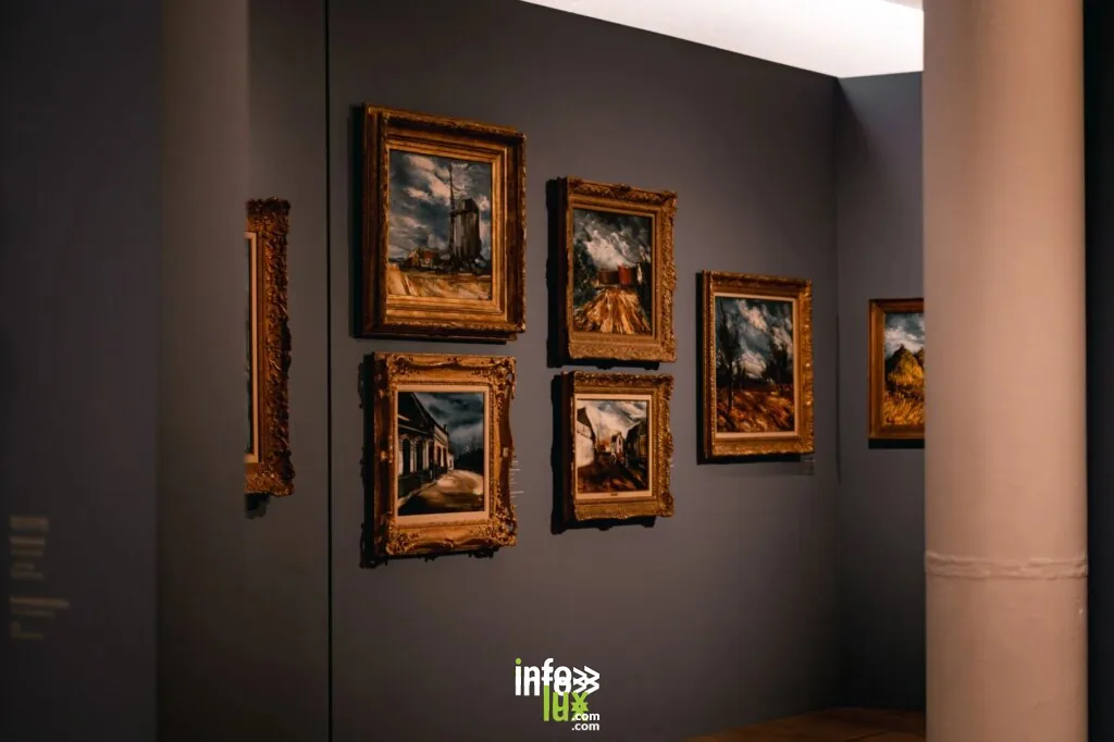 Galerie d'art élégante avec des peintures encadrées sur un mur faiblement éclairé, mettant en valeur des œuvres artistiq