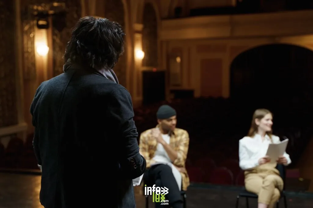 Des acteurs répètent sur une scène de théâtre classique avec des scripts avant la performance.