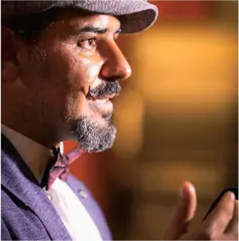 Portrait de Jawad Morad, dessinateur de presse kurde syrien, veste violette et nœud papillon