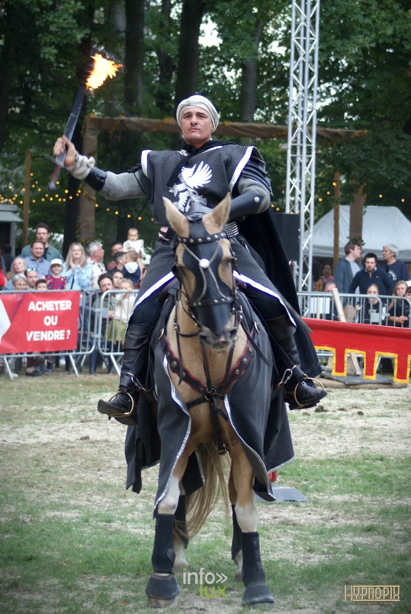 Journées du Cheval 2026 à Braine-l’Alleud, parc du Cheneau : un cavalier en armure et cape noire, torche en main