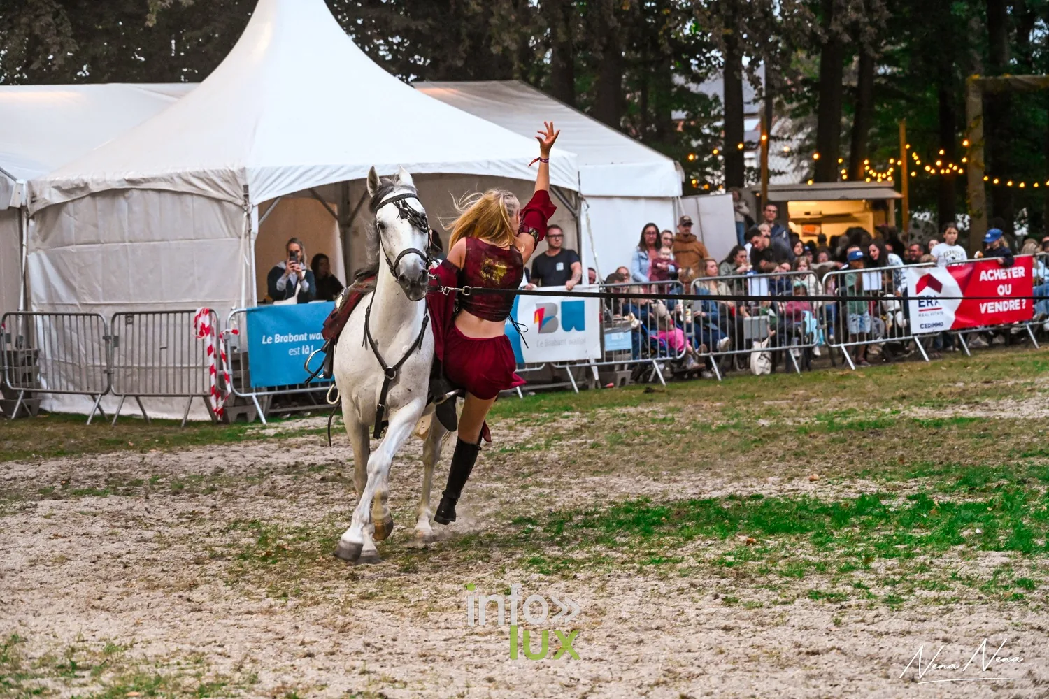 Journées du Cheval 2026 à Braine-l’Alleud, parc du Cheneau : une artiste en costume rouge salue le public aux côtés d’un cheval gris