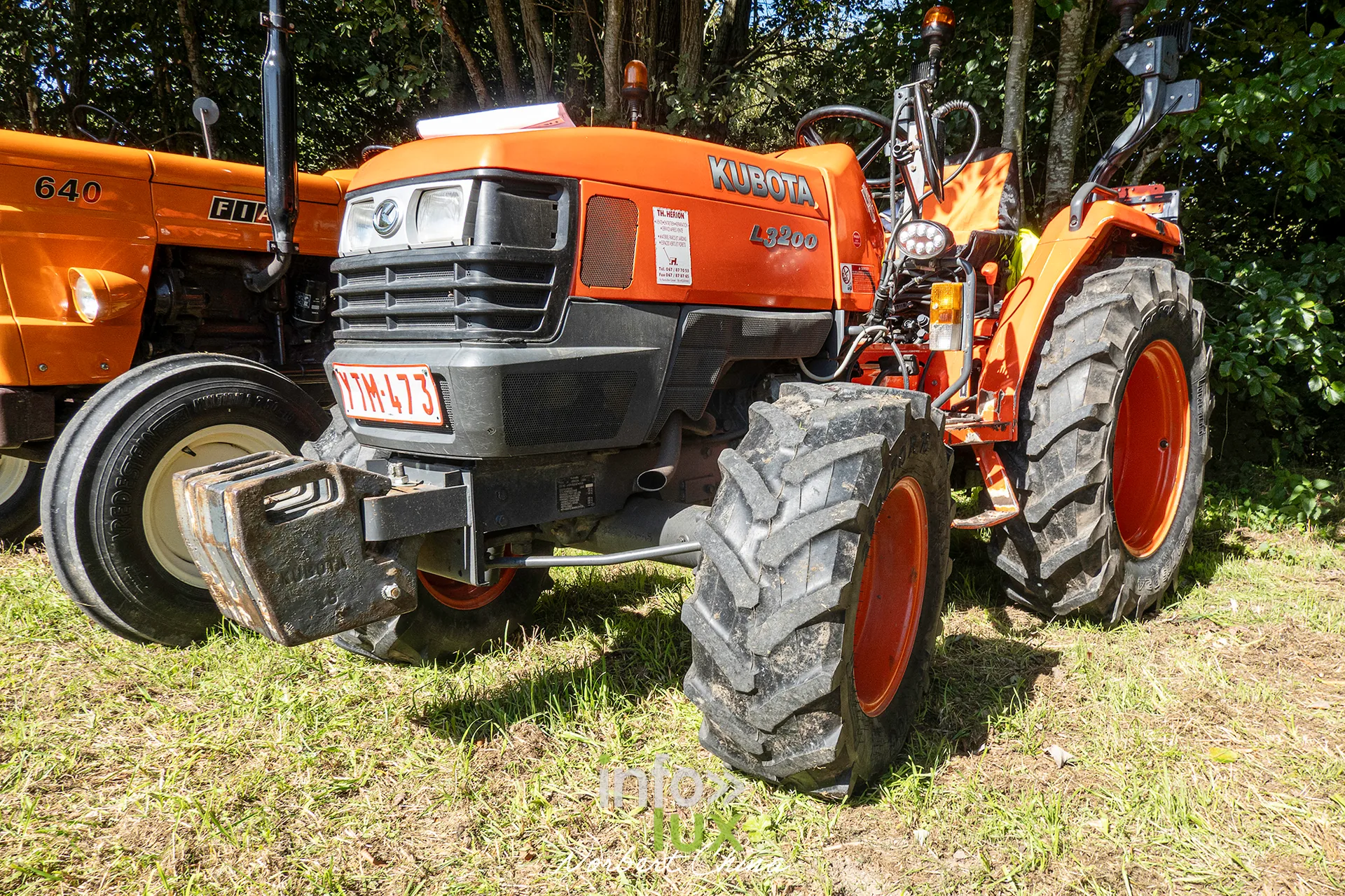 Un tracteur orange moderne exposé dans l'herbe