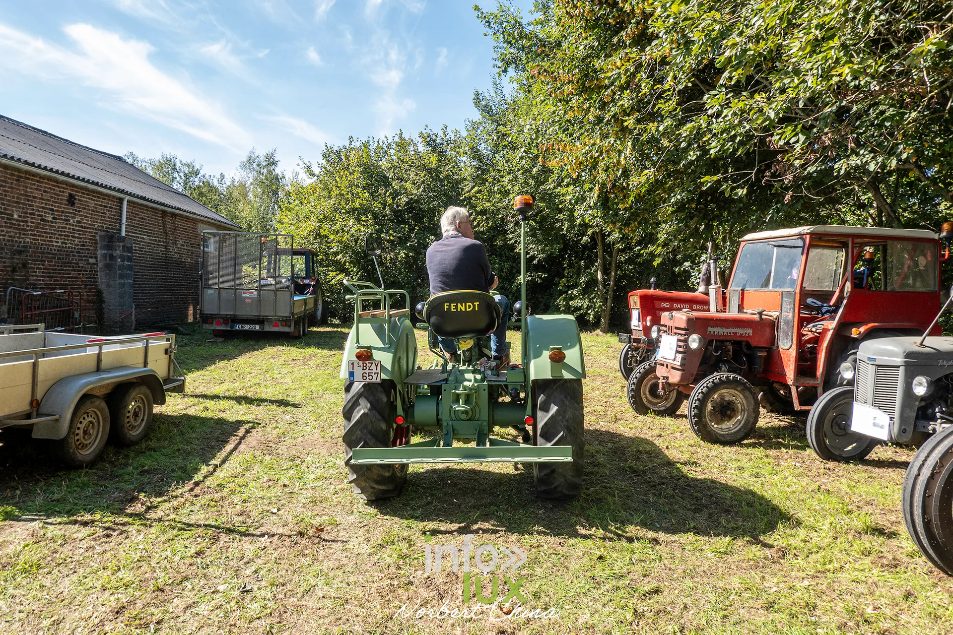 Des tracteurs alignés sous les arbres pendant la kermesse