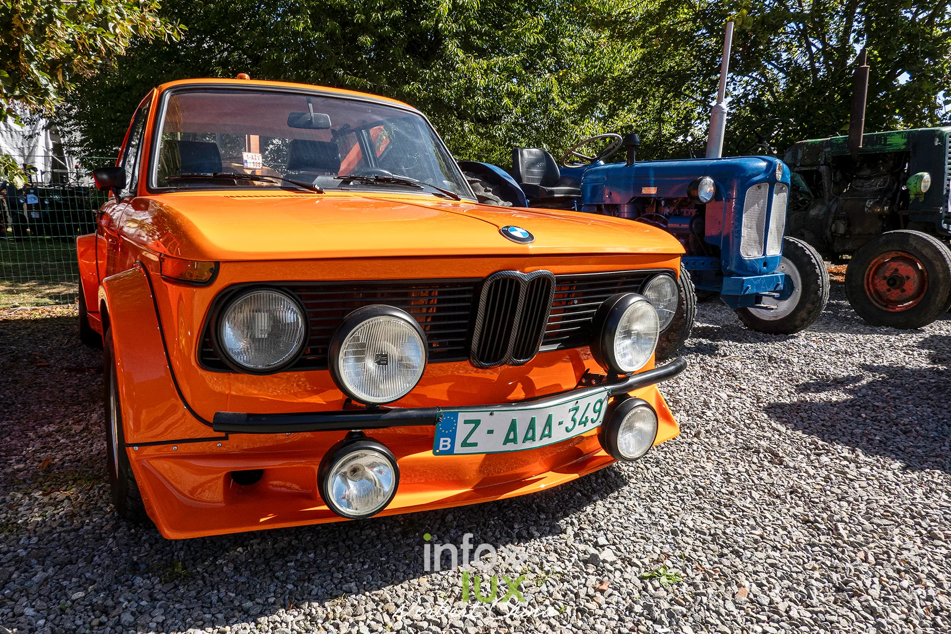 Une BMW 2002 orange exposée sur le site de la kermesse