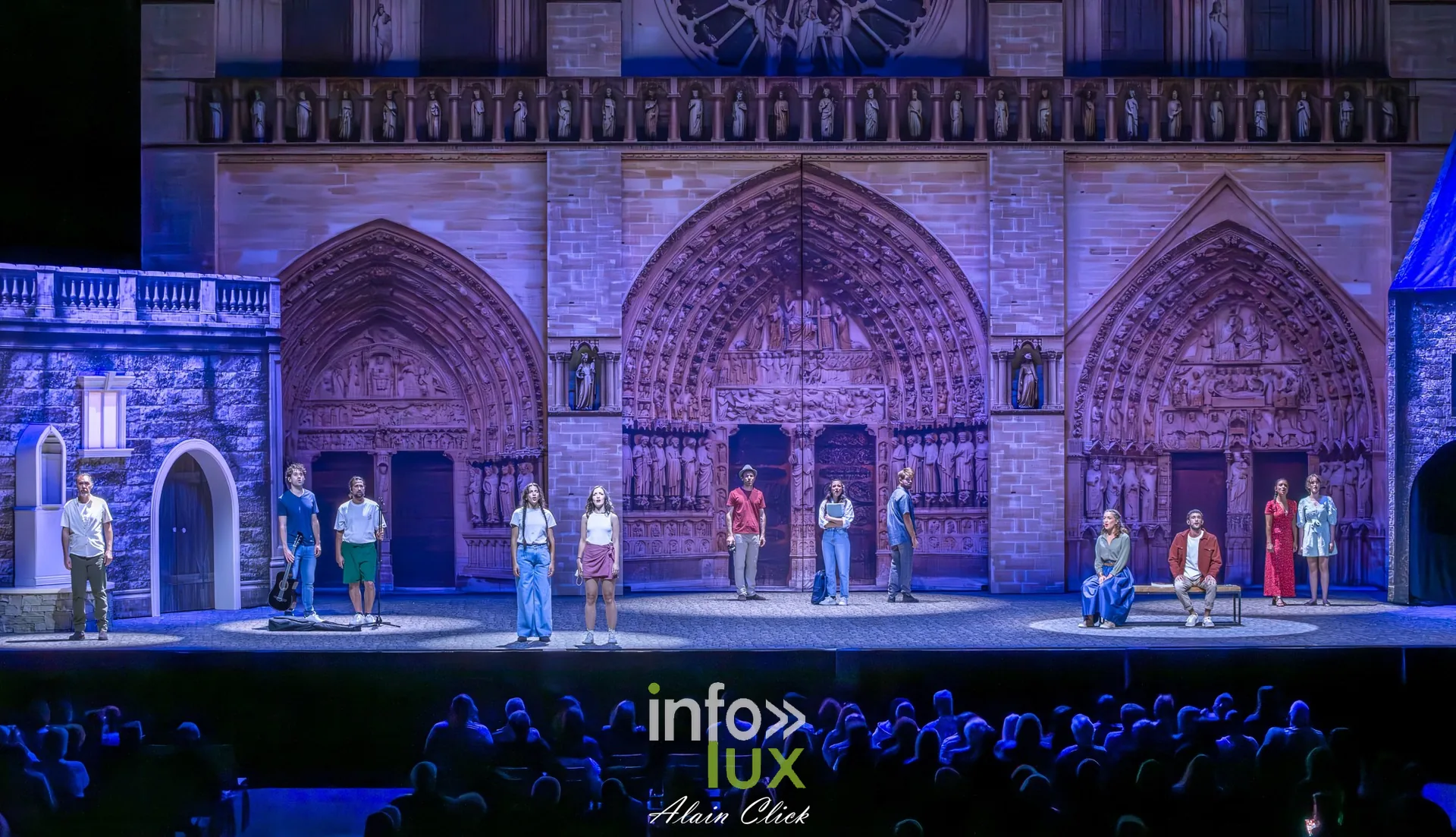 Vue large de la scène : la façade de Notre-Dame en bleu et une dizaine de personnages, La Dame de Pierre