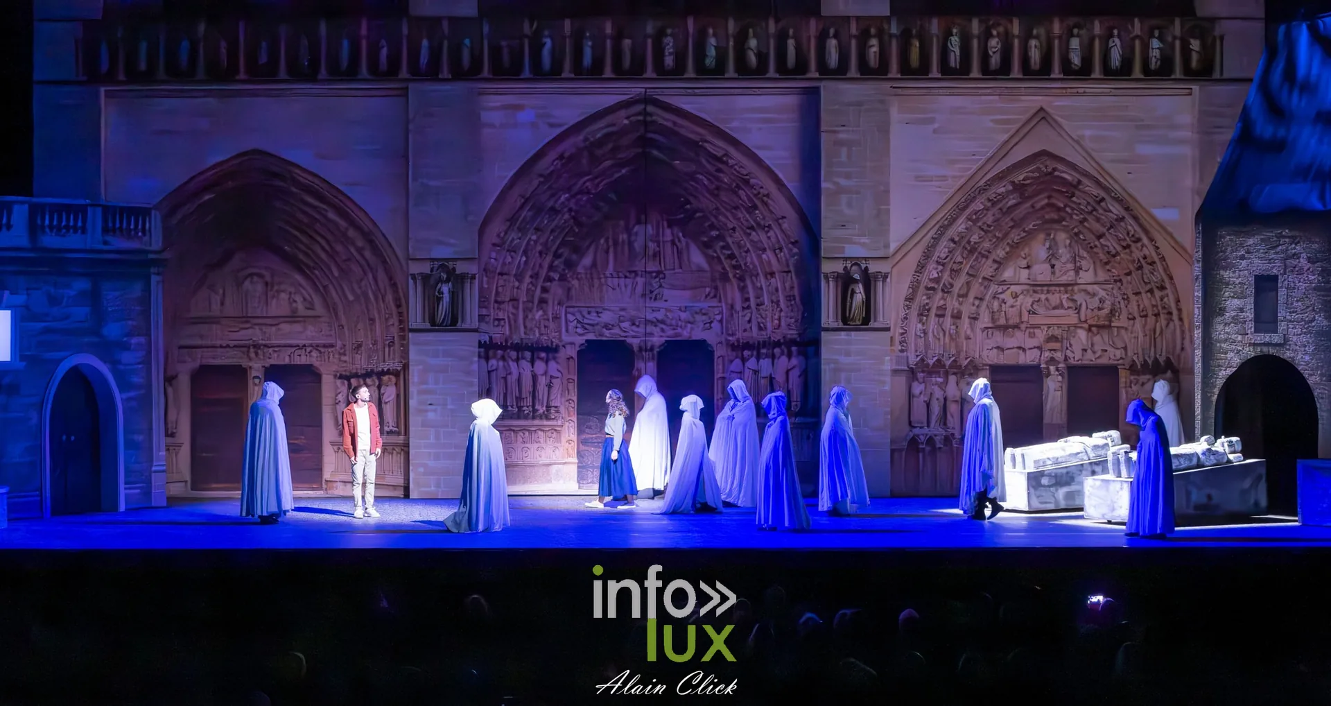 Silhouettes en capes blanches devant la façade bleutée de Notre-Dame, La Dame de Pierre
