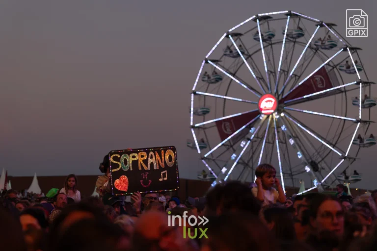 La grande roue illuminée et le panneau Soprano au crépuscule aux Solidarités