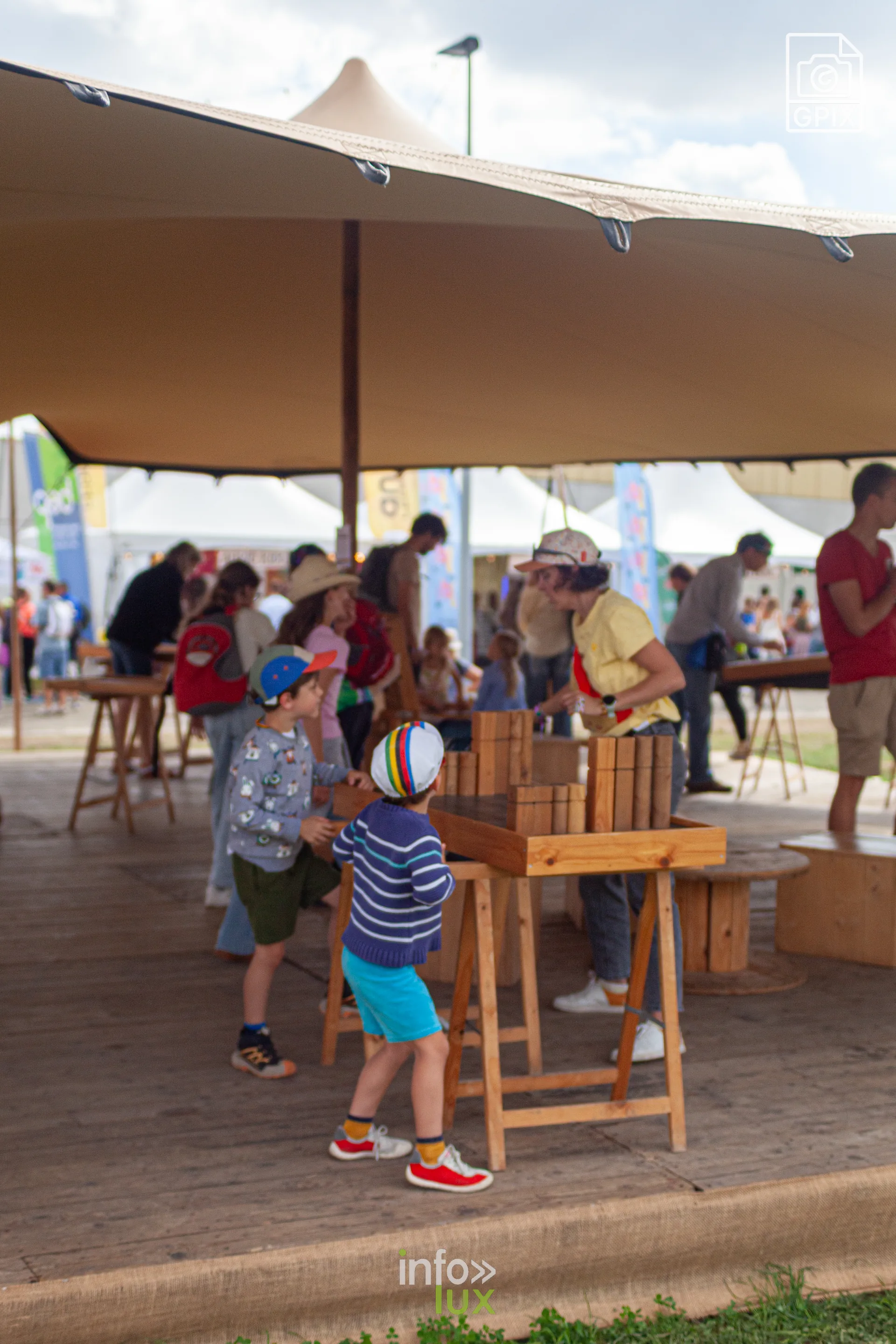 Des enfants jouent sous un chapiteau du village du festival