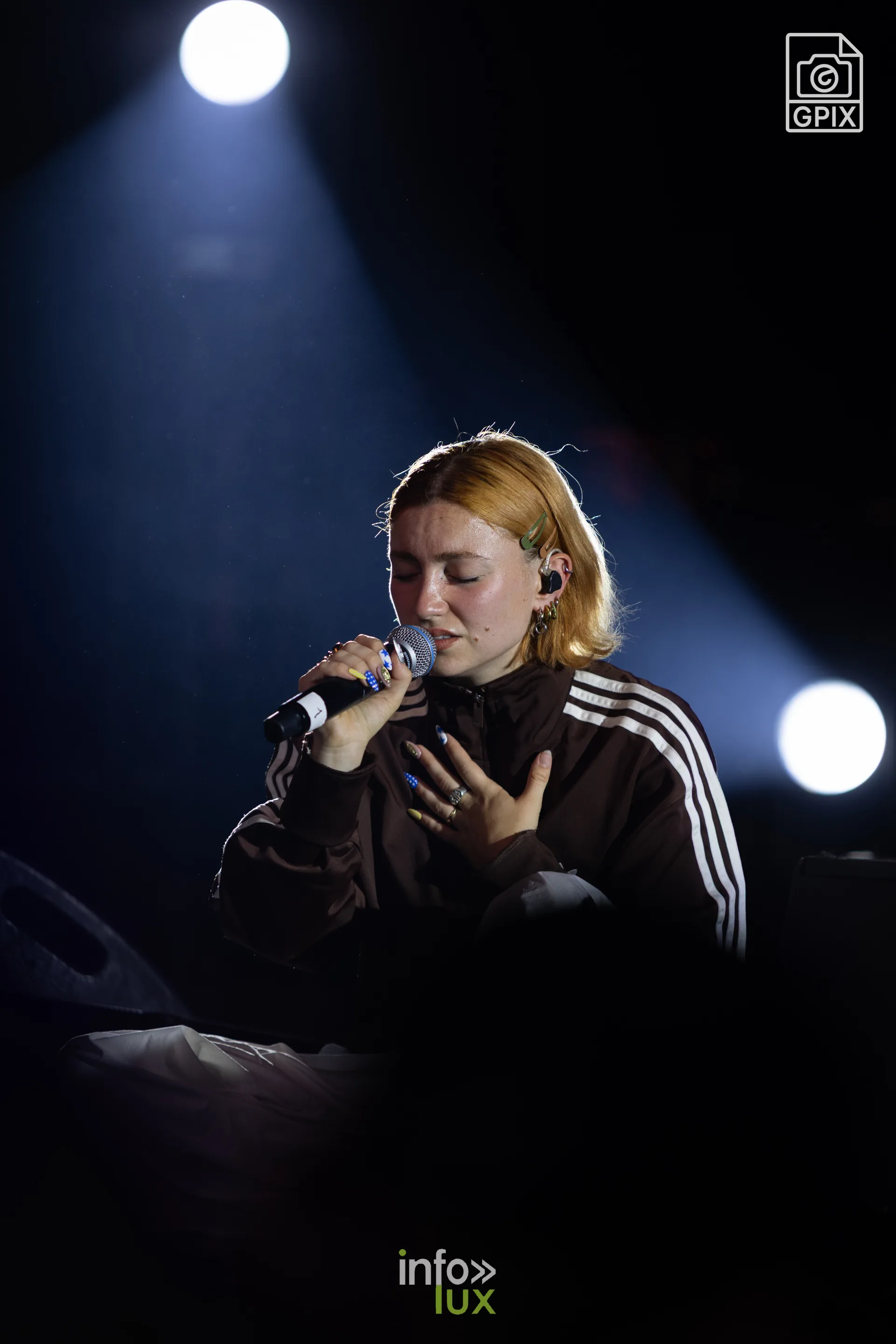 Mado sur scène, éclairée par une lumière blanche