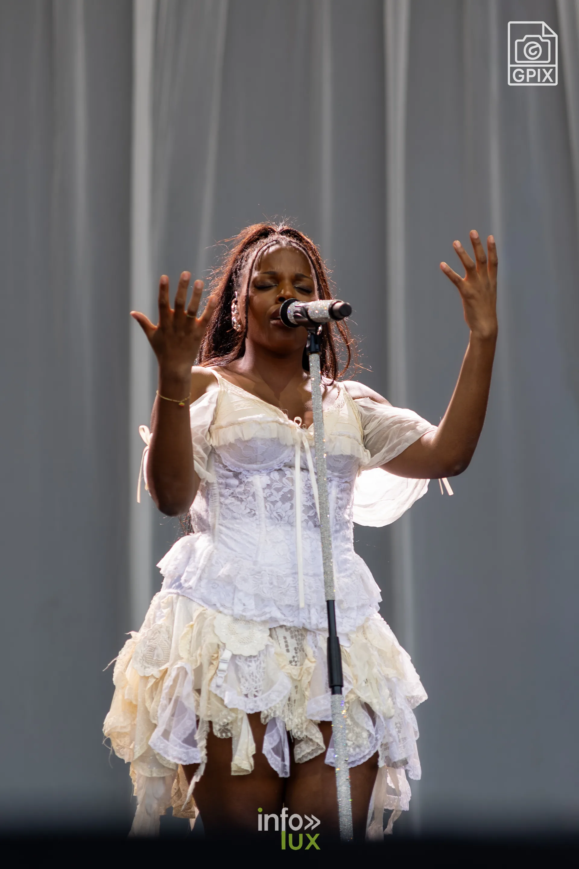 Mentissa les bras levés pendant son concert aux Solidarités
