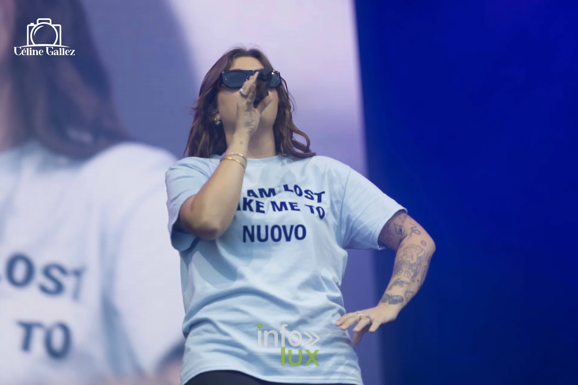 Louane en t-shirt bleu clair et lunettes de soleil sur scène