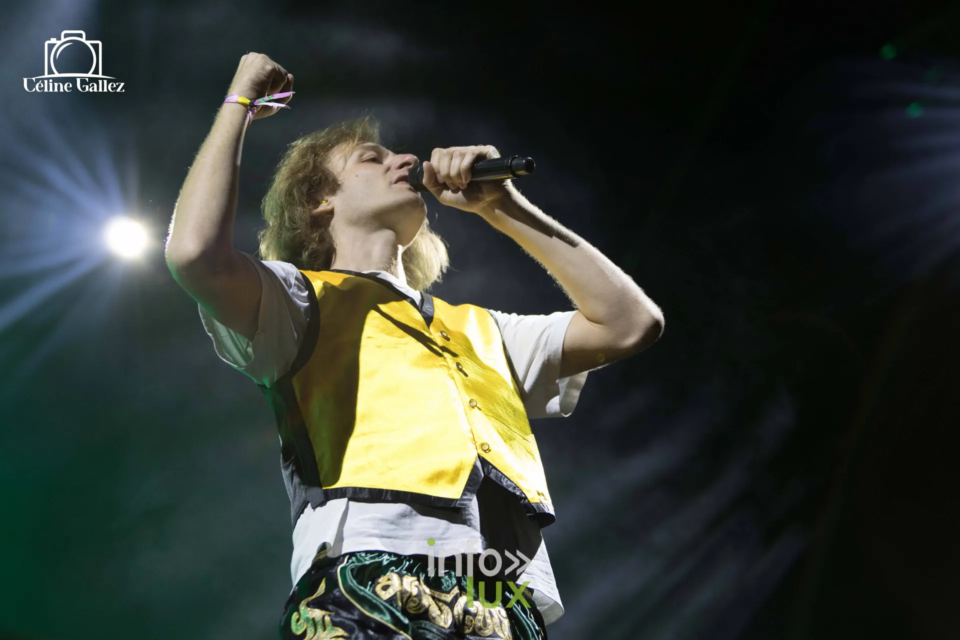 Un artiste en gilet coloré chante au micro