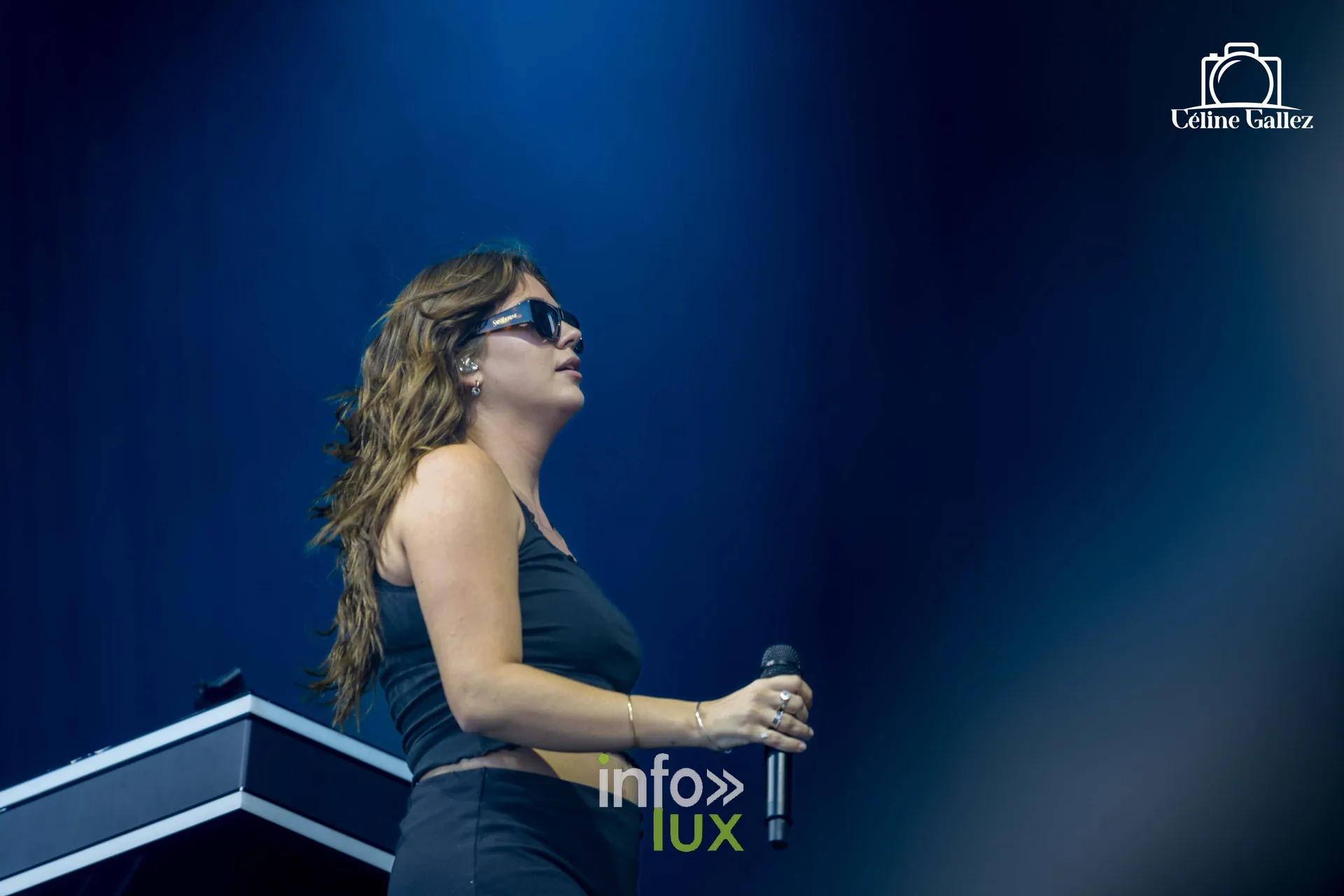 Louane en débardeur noir, silhouette sur fond bleu