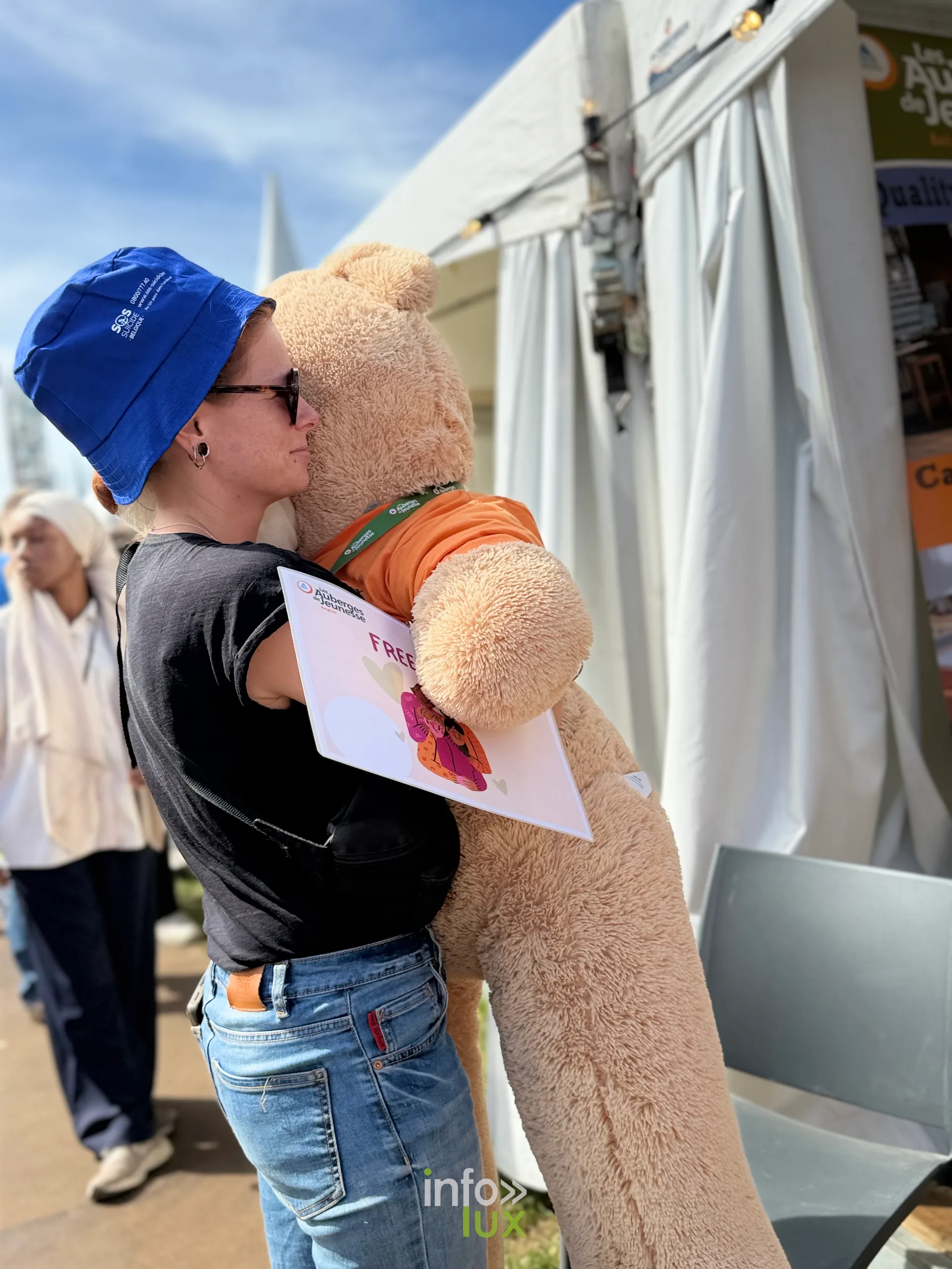 Une festivalière porte une grande peluche gagnée sur le site
