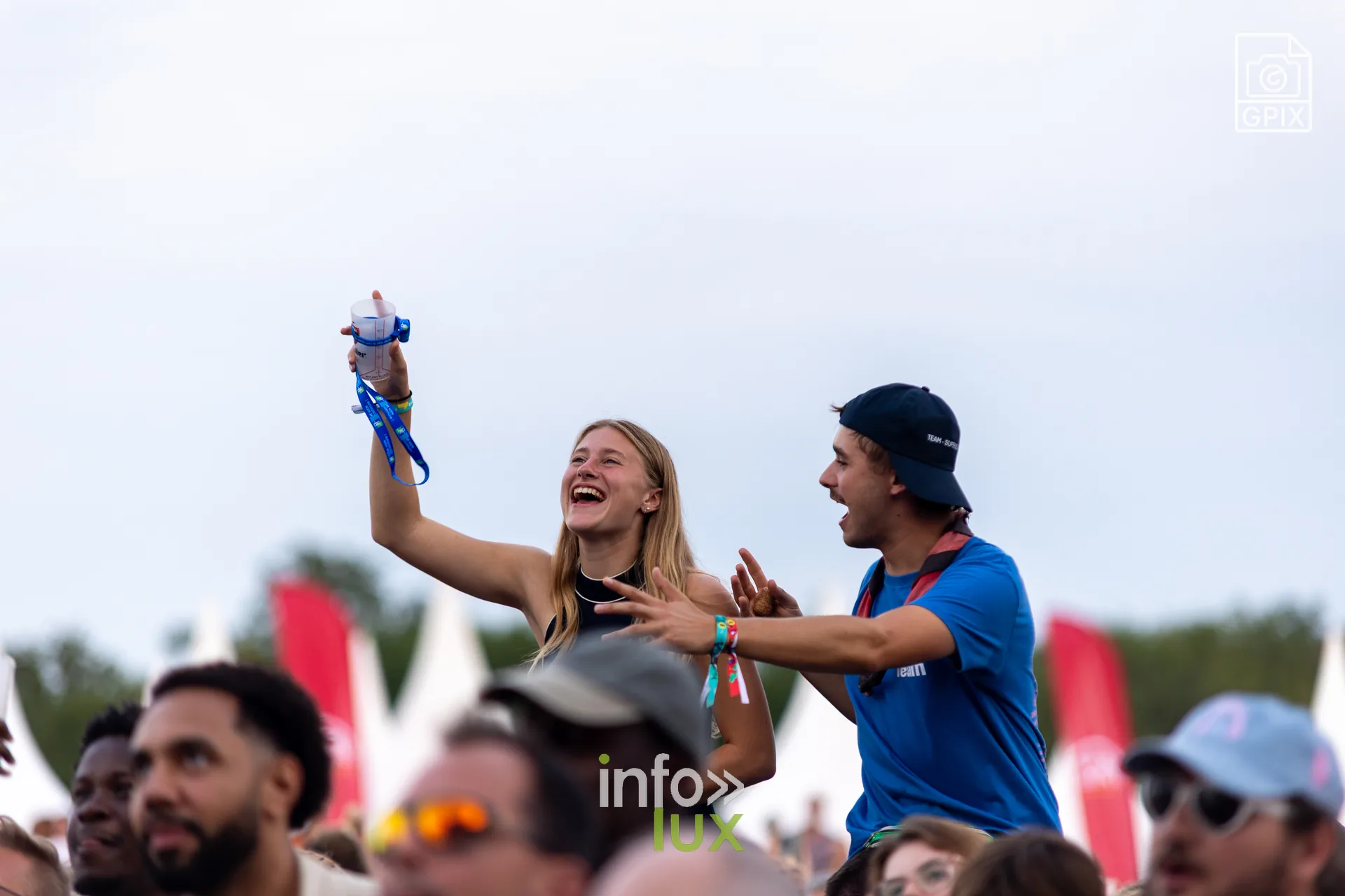 Deux jeunes festivaliers bras levés devant la scène