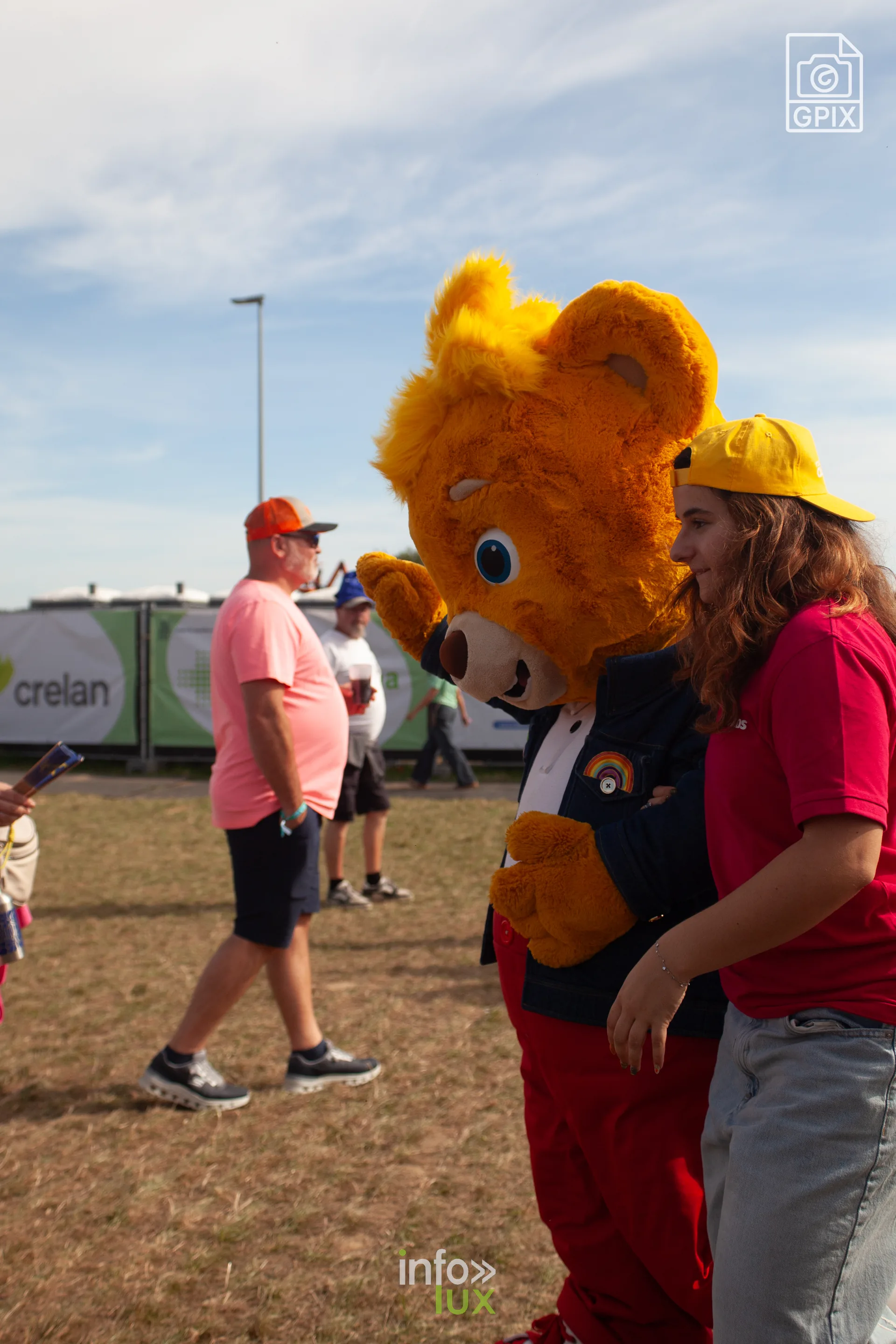 Une mascotte en costume d'ours se promène parmi les festivaliers