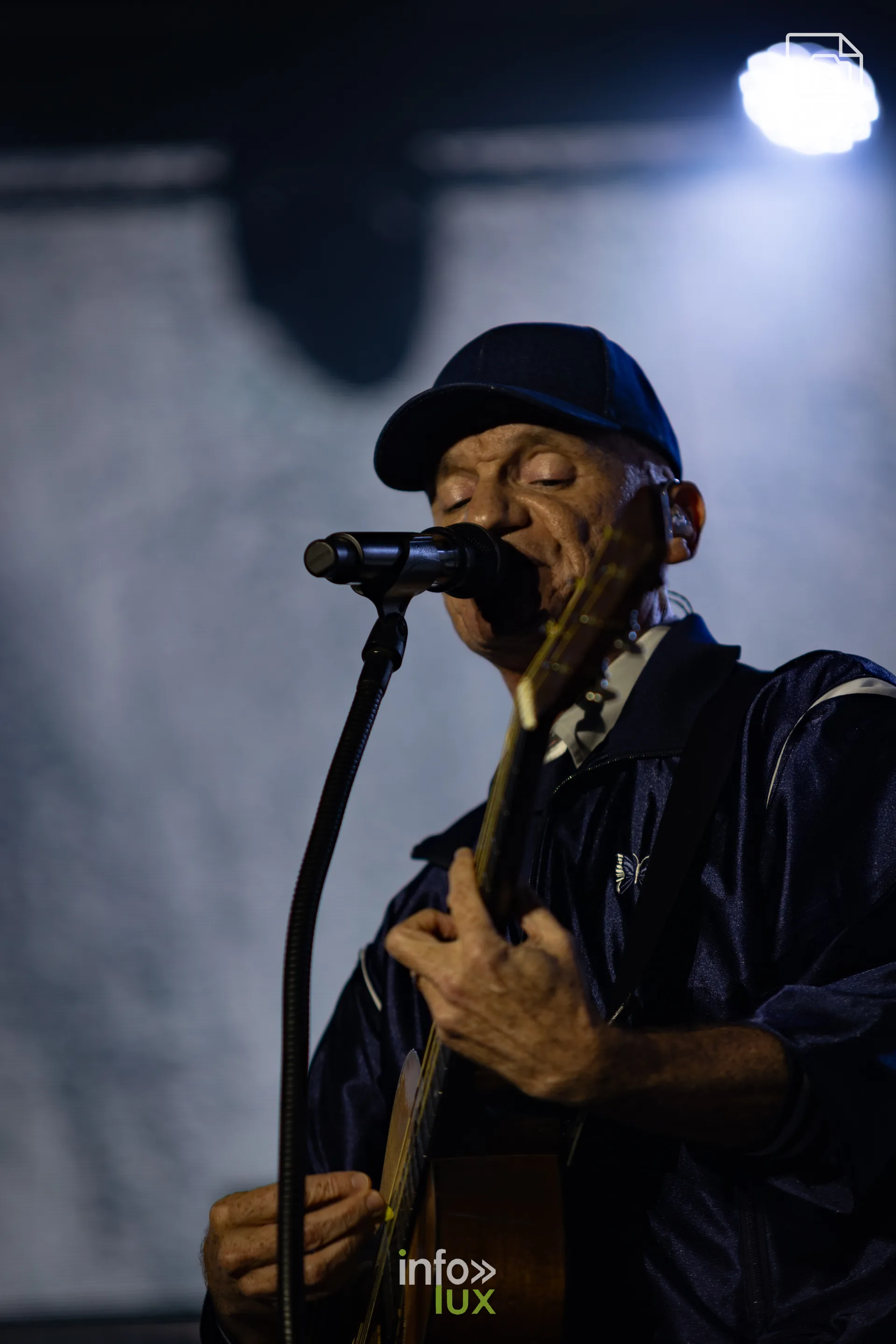 Gaëtan Roussel à la guitare acoustique, casquette vissée sur la tête