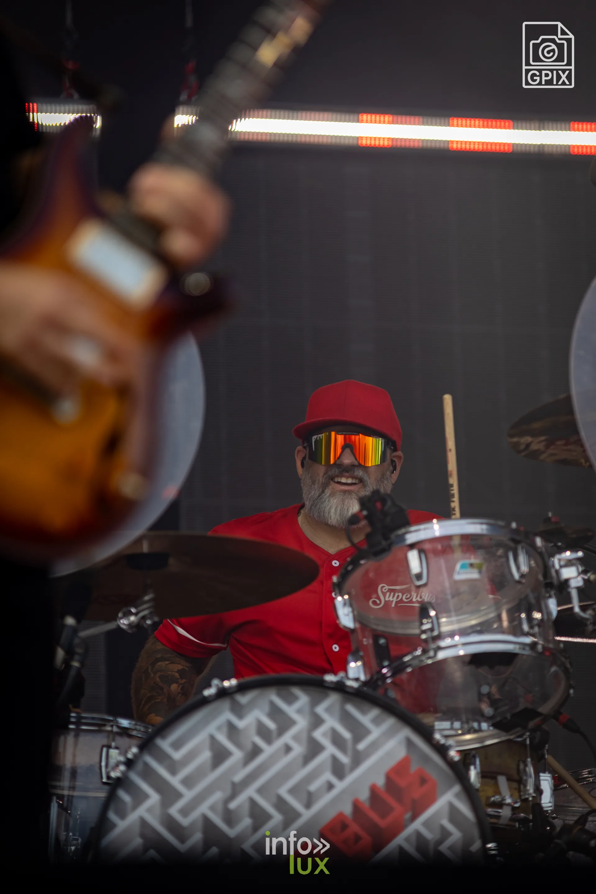 Le batteur de Superbus, casquette rouge et lunettes de soleil