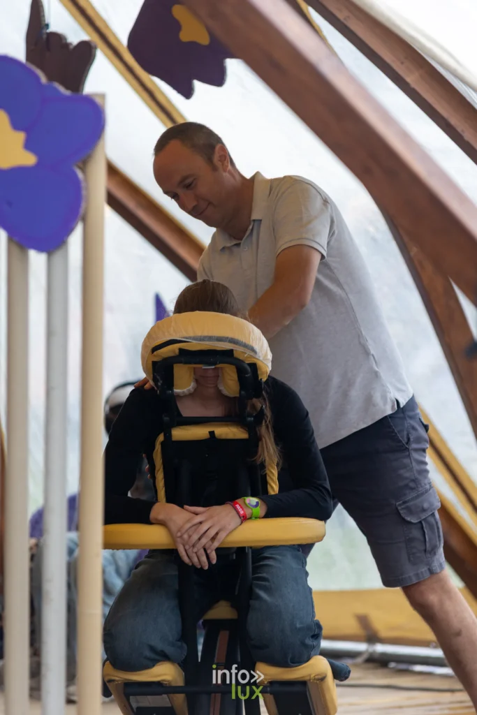 Massage assis dans un espace detente du festival Les Solidarites 2026
