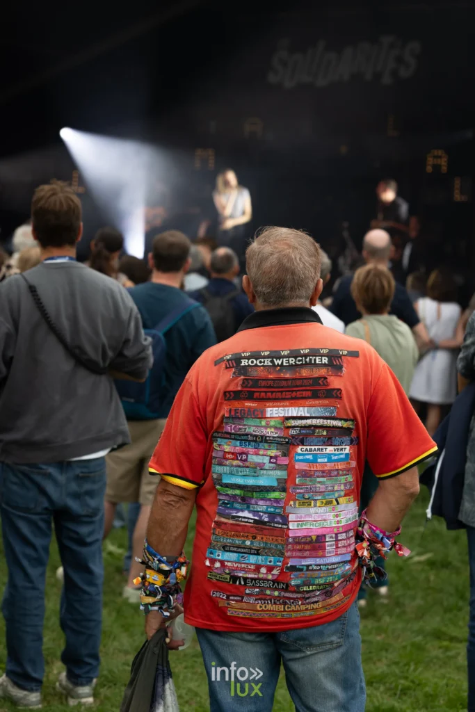 Festivalier portant un tee-shirt couvert de pass de festivals