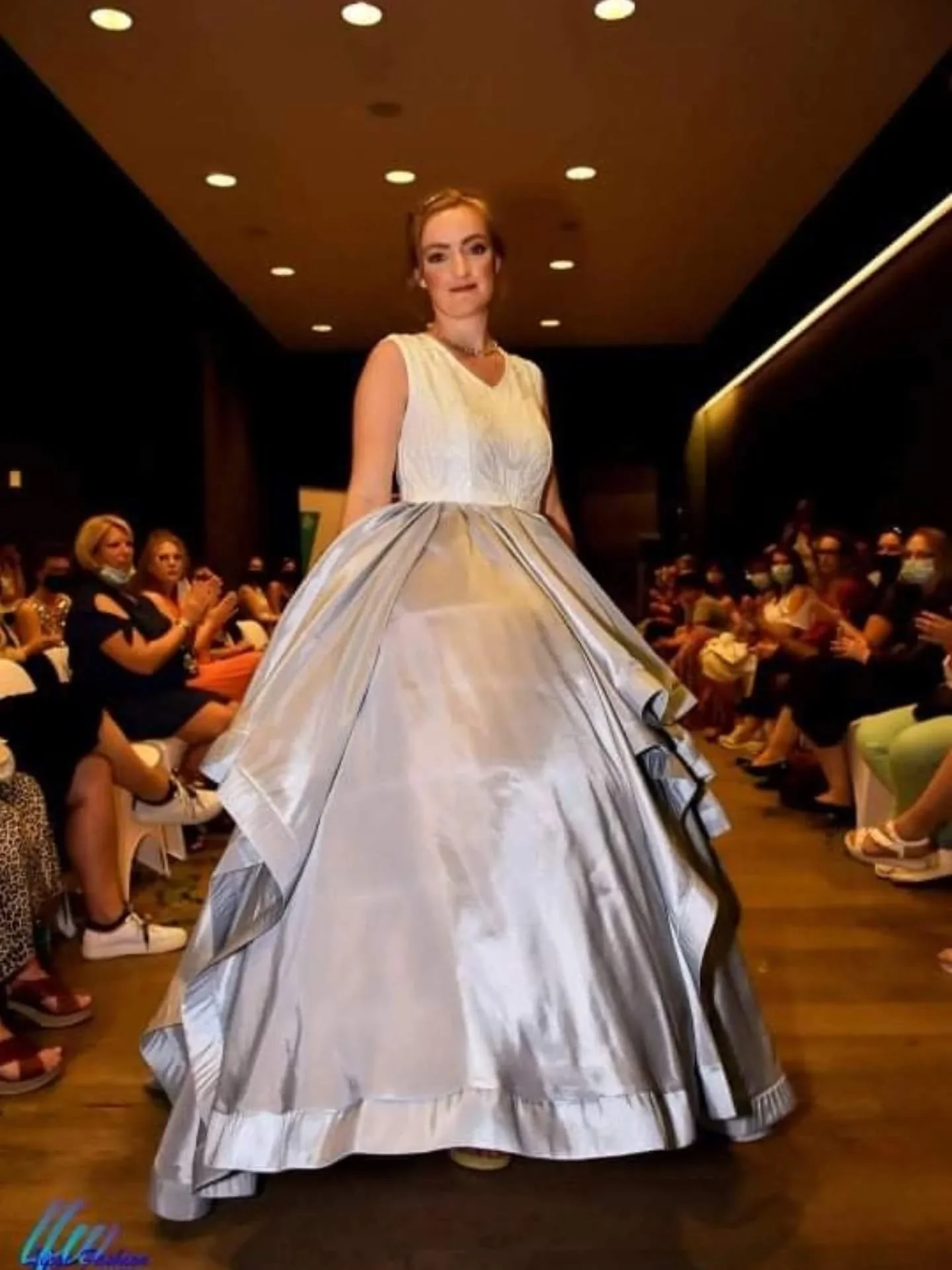 Mannequin en robe de bal argentée sur le podium de la Liège Fashion Week