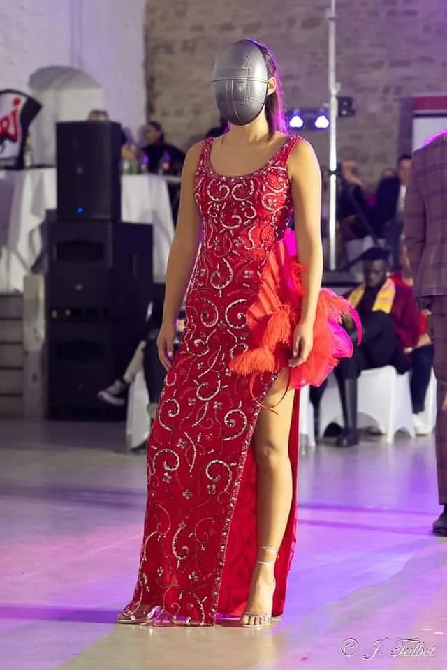Mannequin masquée en robe rouge brodée à la Liège Fashion Week