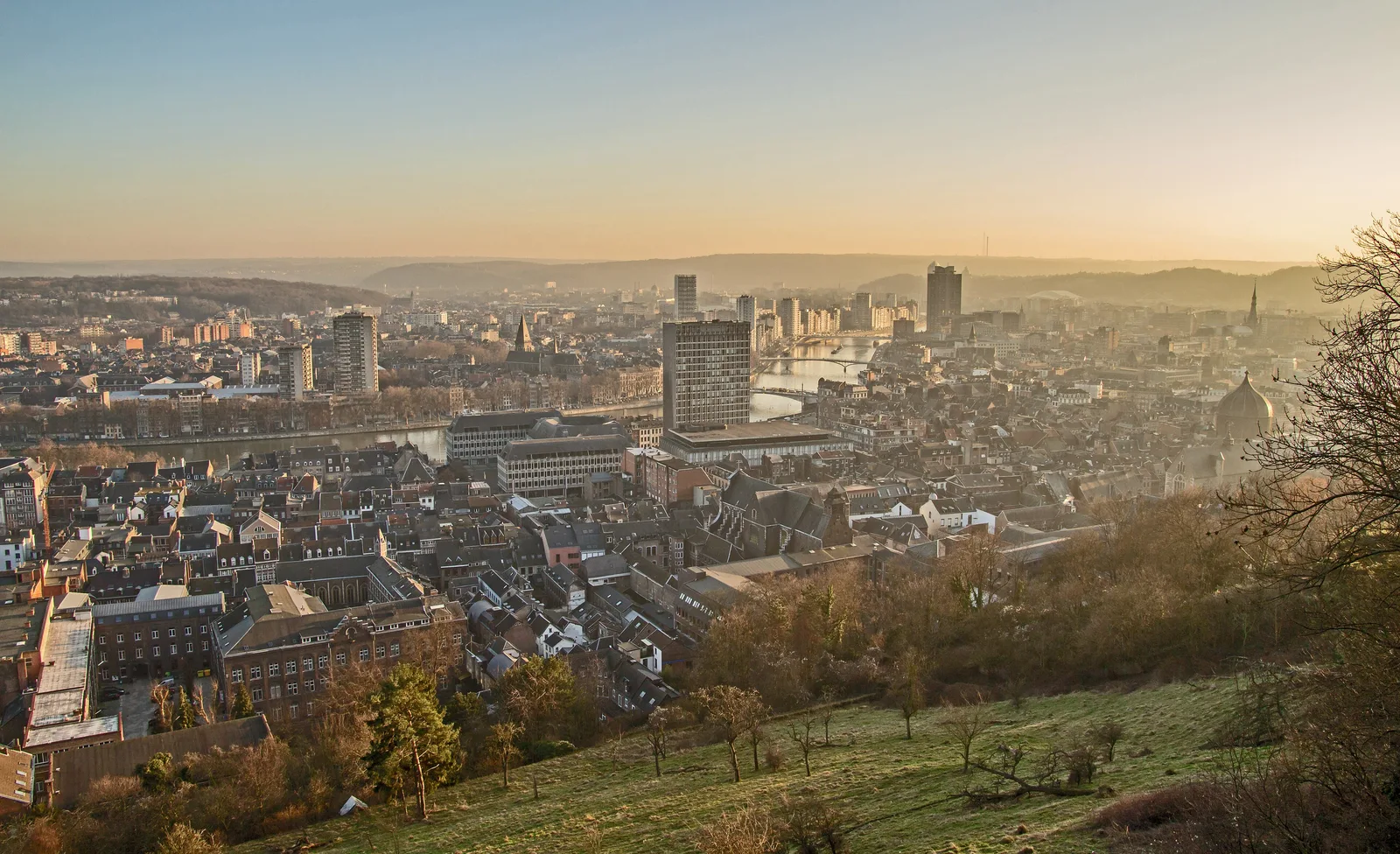Panorama de Liège au coucher du soleil depuis les hauteurs, avec la vallée de la Meuse