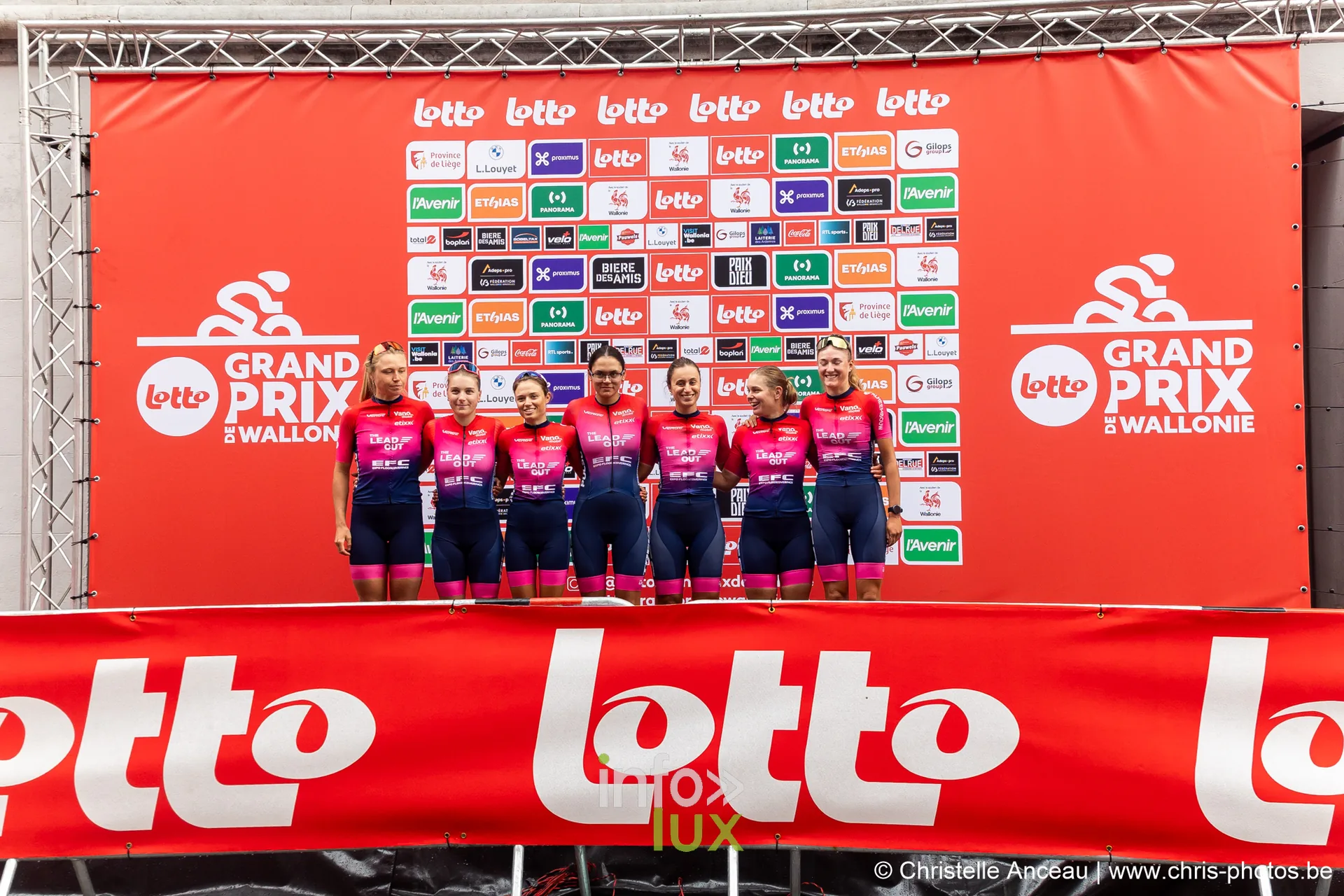 Equipe feminine en maillot rose et rouge posant sur le podium du Grand Prix de Wallonie