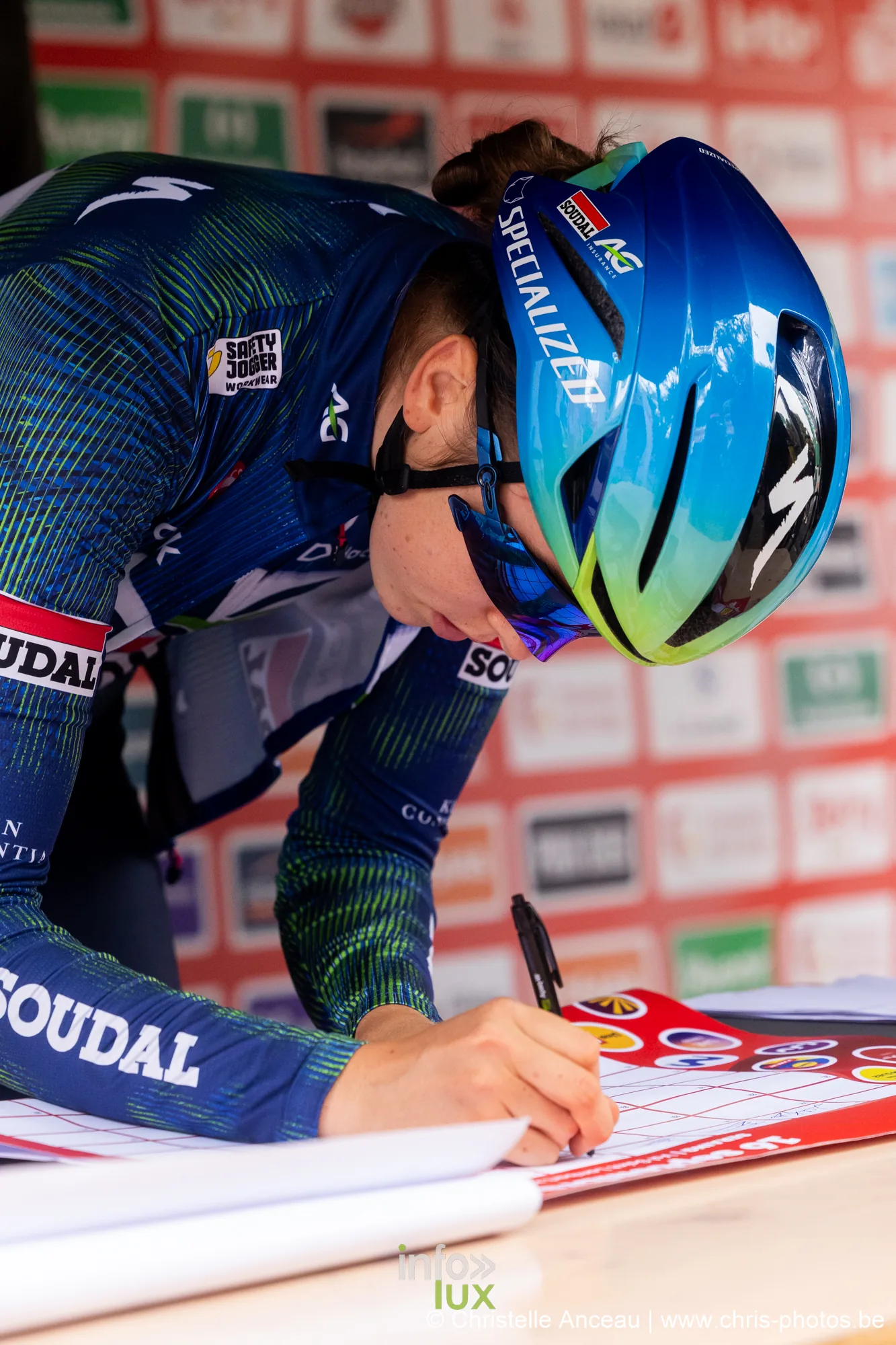 Coureuse en maillot bleu et vert signant la feuille de depart