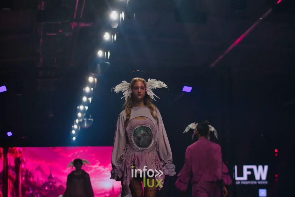 Haut lilas à médaillon imprimé, collants résille, devant un écran rose — Alimac, « Mystic Blossom », Lux Fashion Week 2026, Arlon