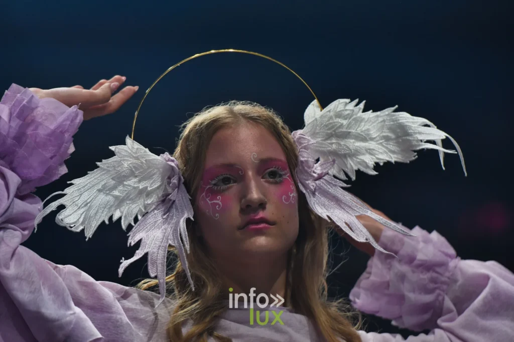 Coiffe d’ailes, manches bouffantes lilas levées — Alimac, « Mystic Blossom », Lux Fashion Week 2026, Arlon