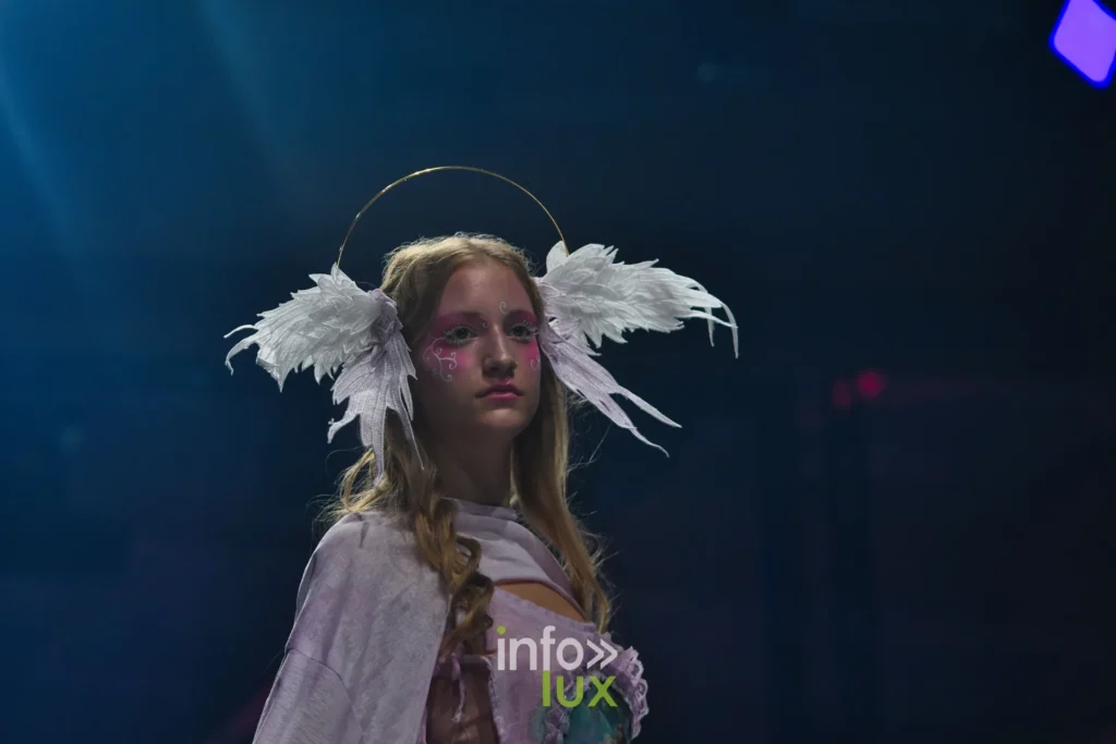 Haut lilas découpé, coiffe d’ailes blanches — Alimac, « Mystic Blossom », Lux Fashion Week 2026, Arlon