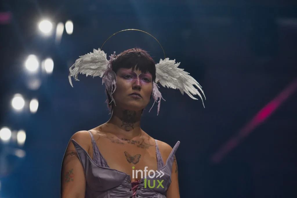 Corset en satin lilas lacé, coiffe d’ailes, bras tatoués — Alimac, « Mystic Blossom », Lux Fashion Week 2026, Arlon