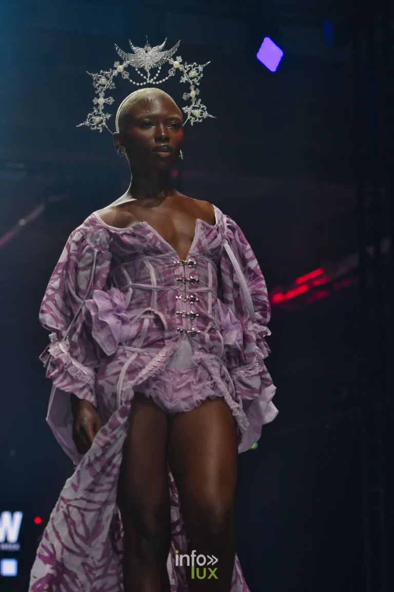 Robe-corset à imprimé mauve fermée par des agrafes métalliques, manches bouffantes, auréole en filigrane argenté — Alimac, « Mystic Blossom », Lux Fashion Week 2026, Arlon