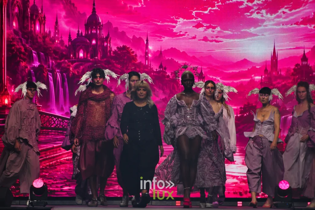 Le groupe final devant le décor rose projeté à l’écran — Alimac, « Mystic Blossom », Lux Fashion Week 2026, Arlon