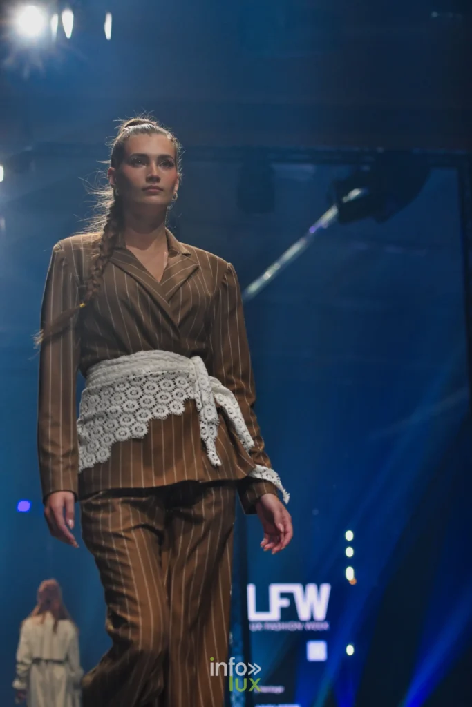 Tailleur brun à rayures et ceinture de dentelle blanche, longue tresse — Violette Briel, « L’Héritage », Lux Fashion Week 2026, Arlon