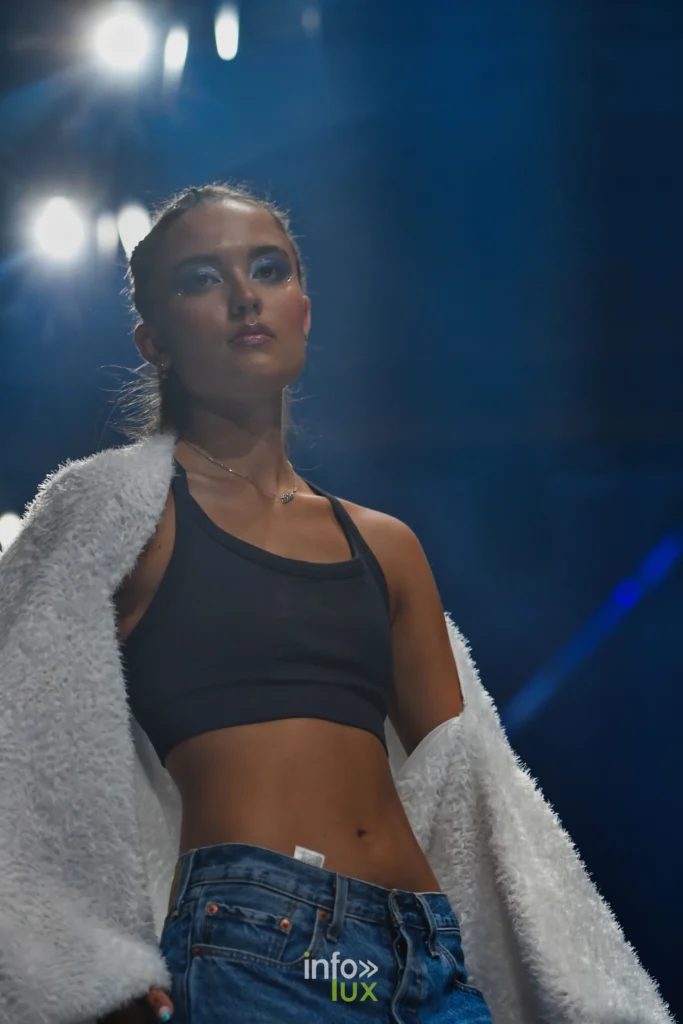 Veste blanche à longs poils, brassière noire et jean — Violette Briel, « L’Héritage », Lux Fashion Week 2026, Arlon