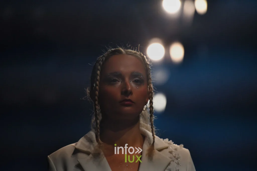 Portrait : tresses, veste crème ornée de perles — Violette Briel, « L’Héritage », Lux Fashion Week 2026, Arlon