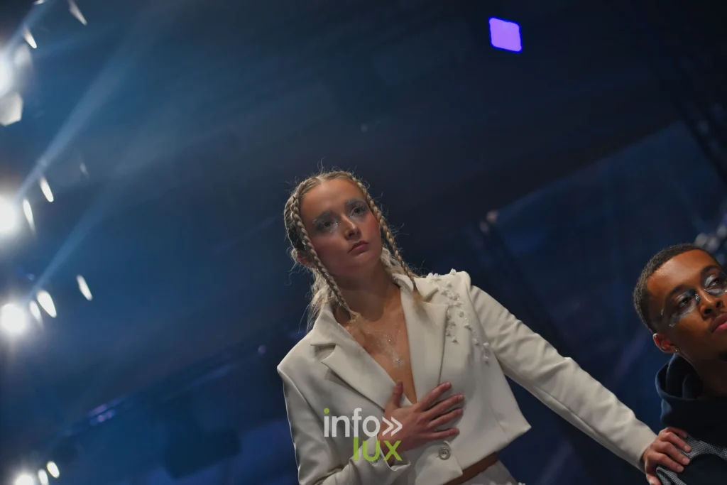 Veste crème ornée de perles, main sur le cœur, au bout du podium — Violette Briel, « L’Héritage », Lux Fashion Week 2026, Arlon