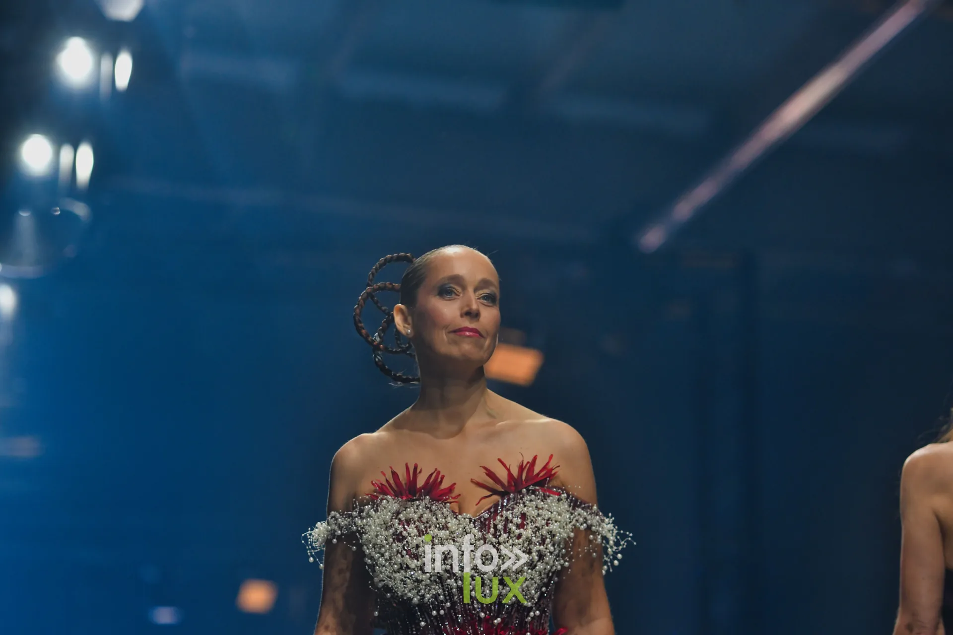 Bustier couvert de gypsophile blanche et de fleurs rouges, coiffure tressée en volutes, collection « Le Fil Sacré » de Christelle Bukasa, Lux Fashion Week 2026, Arlon