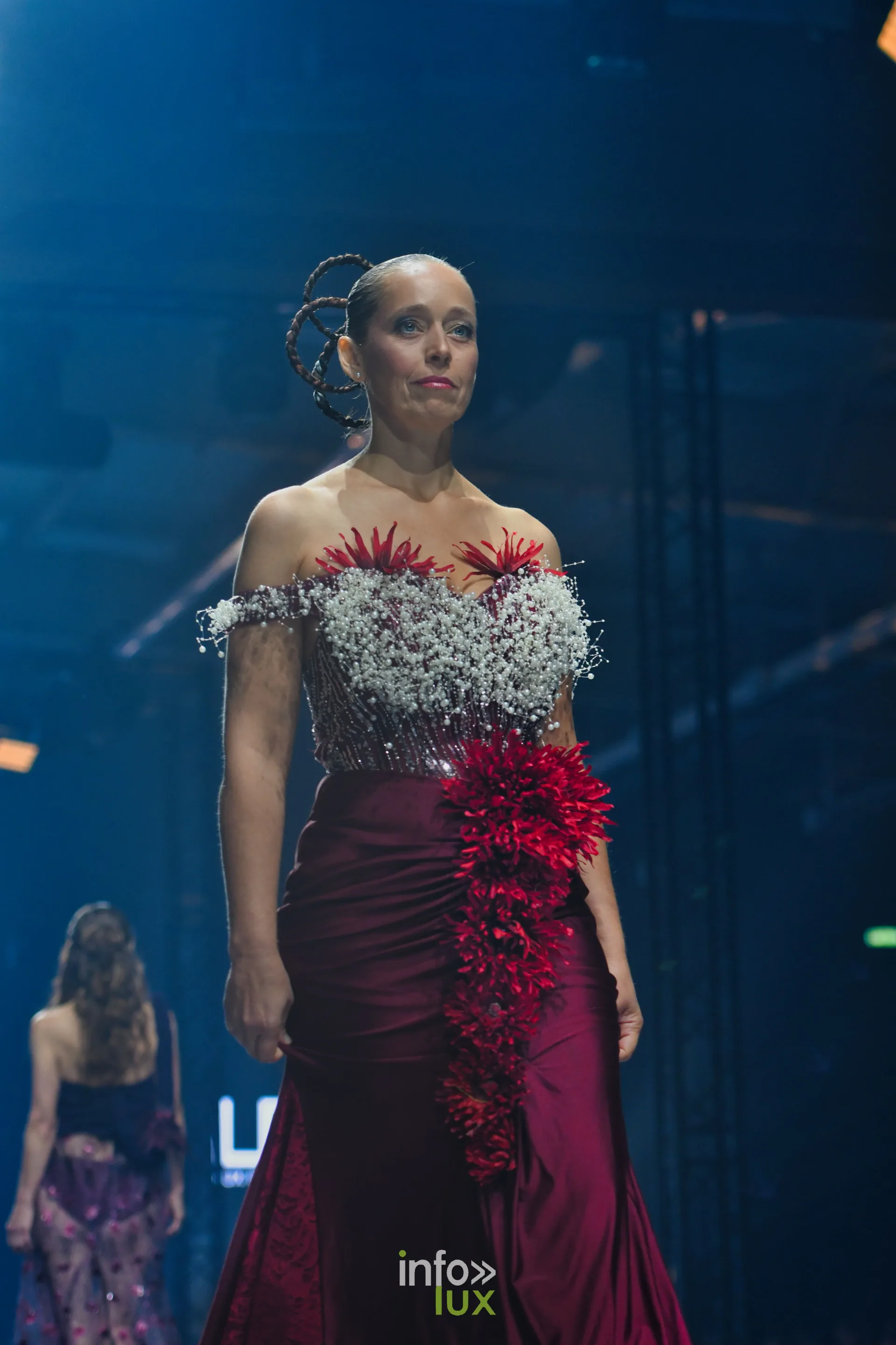 Bustier de gypsophile et de fleurs rouges, jupe longue en satin bordeaux et cascade de fleurs rouges, collection « Le Fil Sacré » de Christelle Bukasa, Lux Fashion Week 2026, Arlon