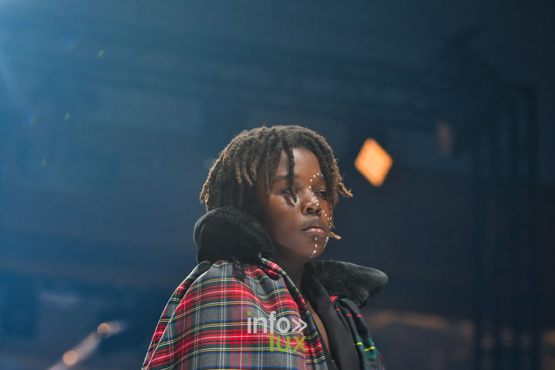 Jeune mannequin en cape de tartan rouge, collection « Le Fil Sacré » de Christelle Bukasa, Lux Fashion Week 2026, Arlon