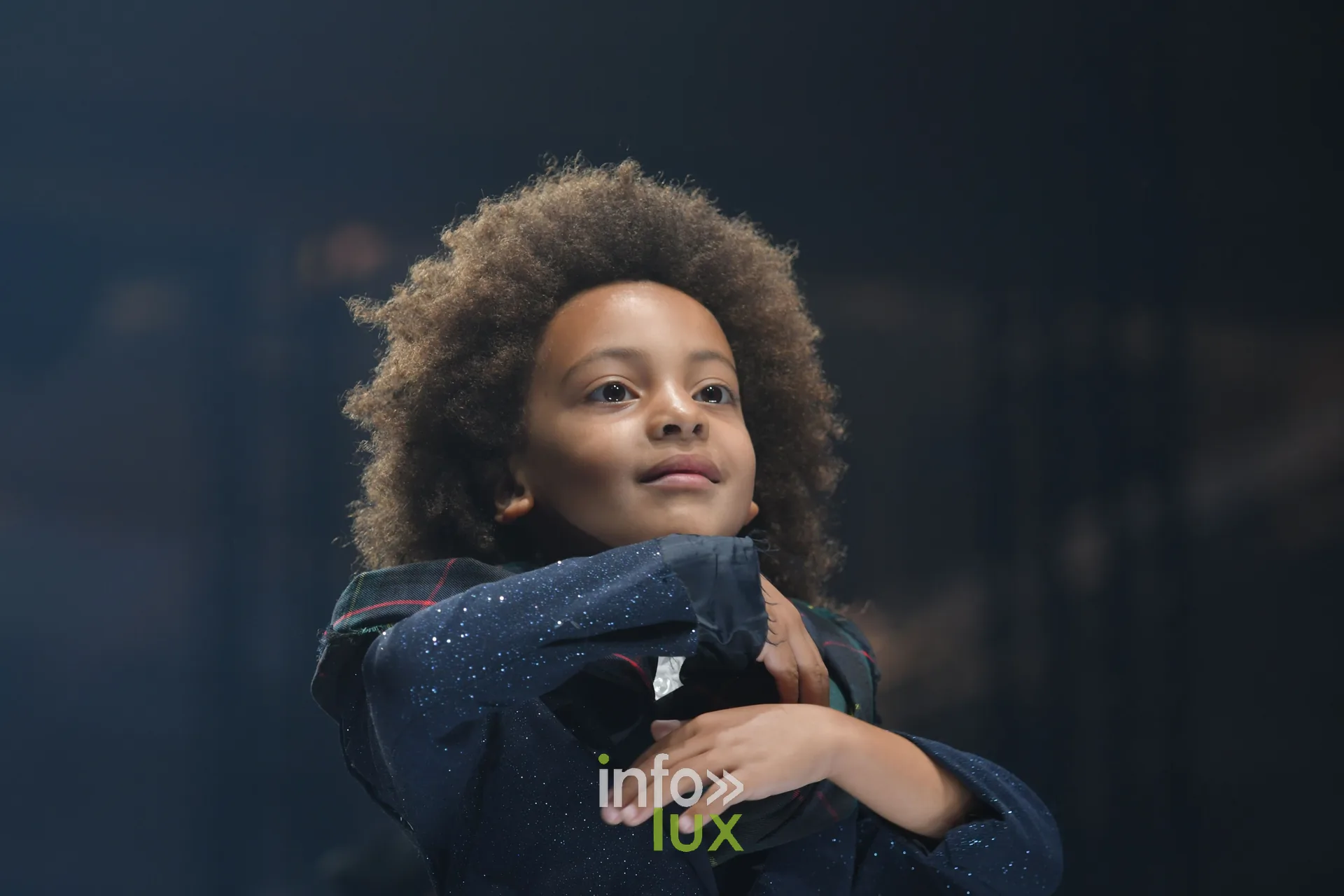 Jeune mannequin en veste bleu marine pailletée, collection « Le Fil Sacré » de Christelle Bukasa, Lux Fashion Week 2026, Arlon