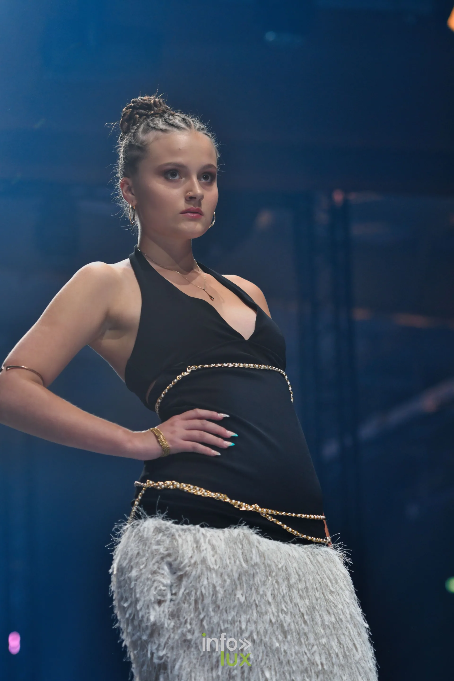 Haut noir dos nu à col licou, chaînes dorées à la taille et jupe longue à franges grises, collection « Le Fil Sacré » de Christelle Bukasa, Lux Fashion Week 2026, Arlon