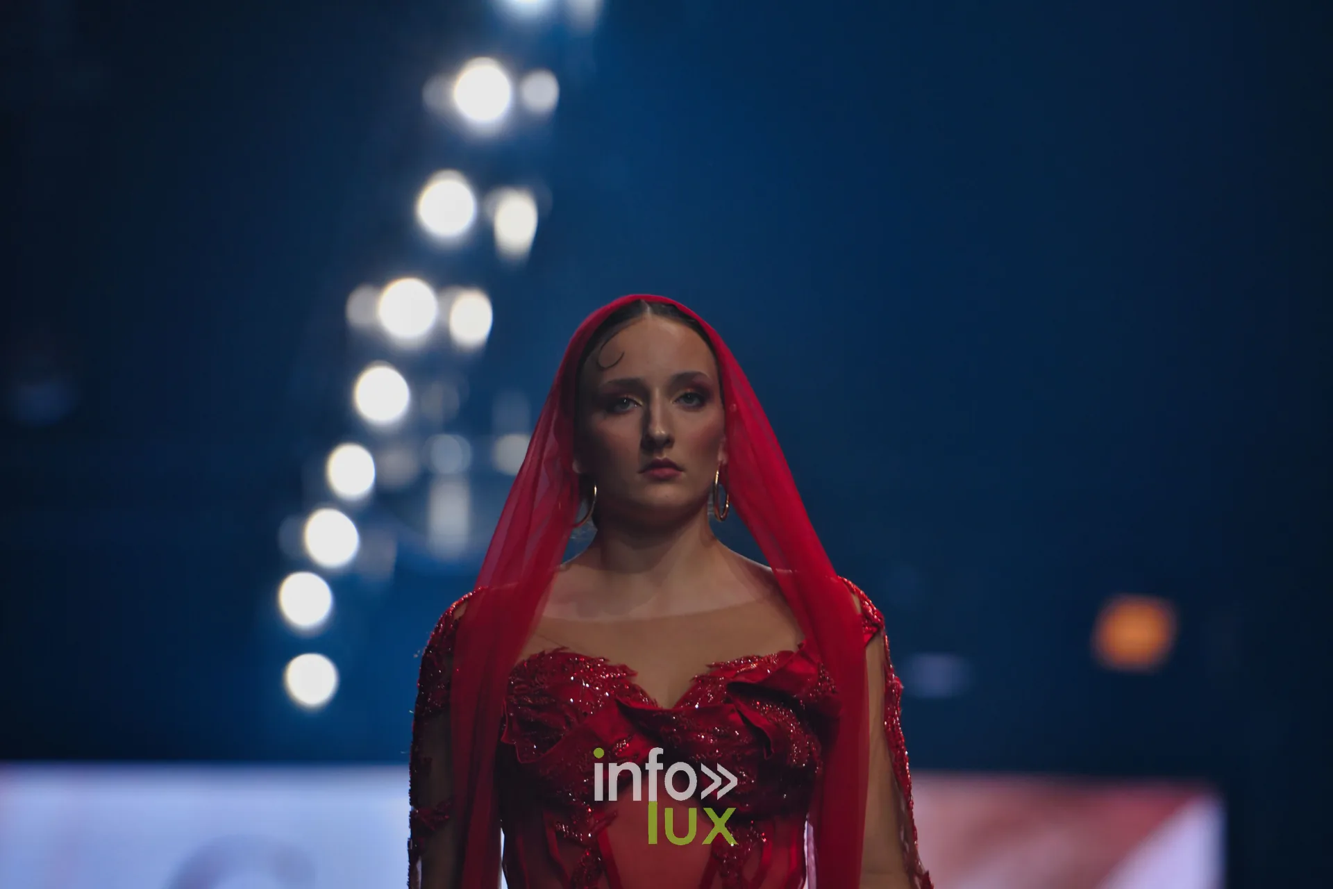 Voile rouge sur la tête et robe rouge brodée à corsage transparent, collection « Le Fil Sacré » de Christelle Bukasa, Lux Fashion Week 2026, Arlon