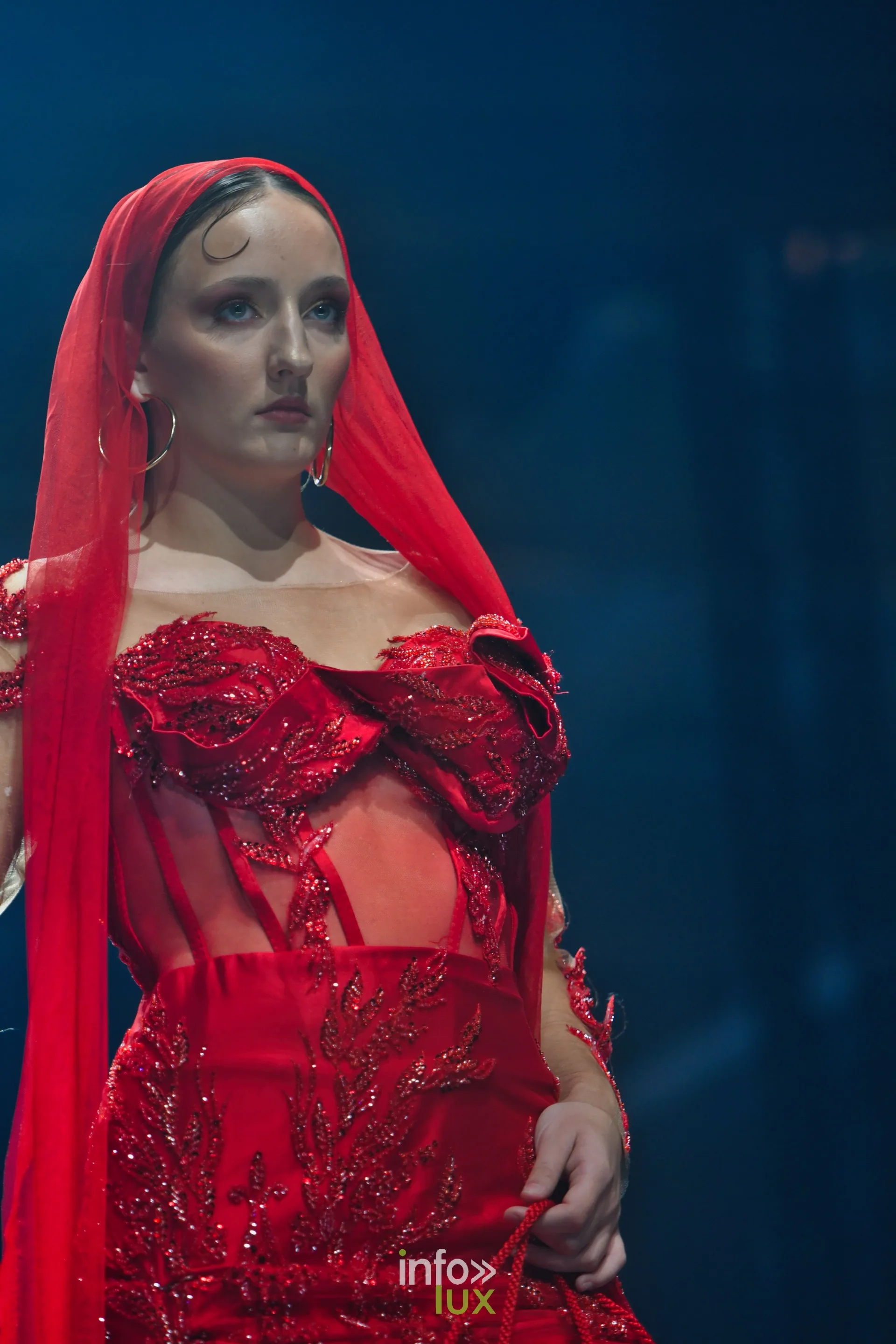 Robe rouge brodée de perles et de sequins, avec un voile rouge, collection « Le Fil Sacré » de Christelle Bukasa, Lux Fashion Week 2026, Arlon