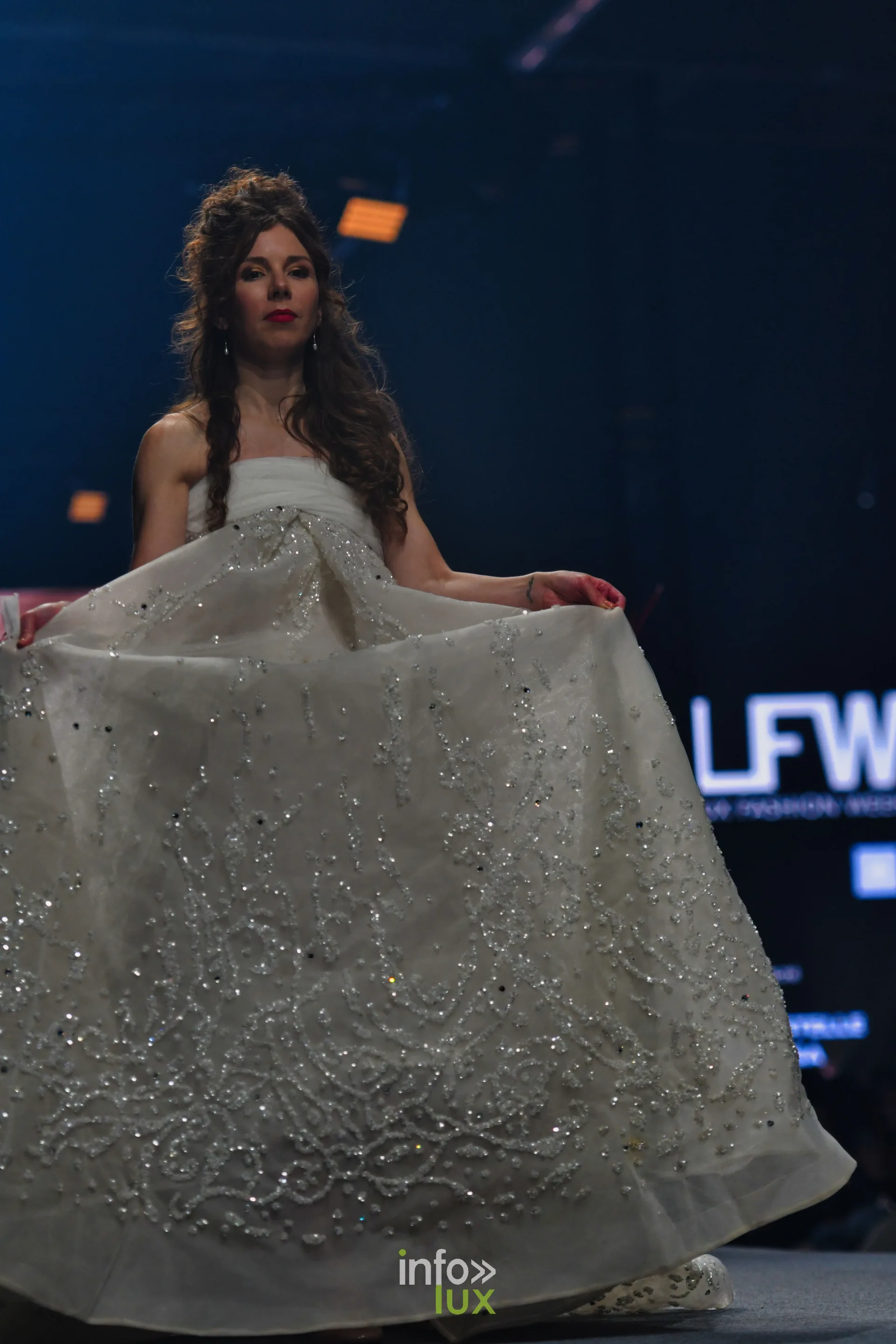 Robe de bal ivoire brodée de sequins, jupe tenue à deux mains, collection « Le Fil Sacré » de Christelle Bukasa, Lux Fashion Week 2026, Arlon